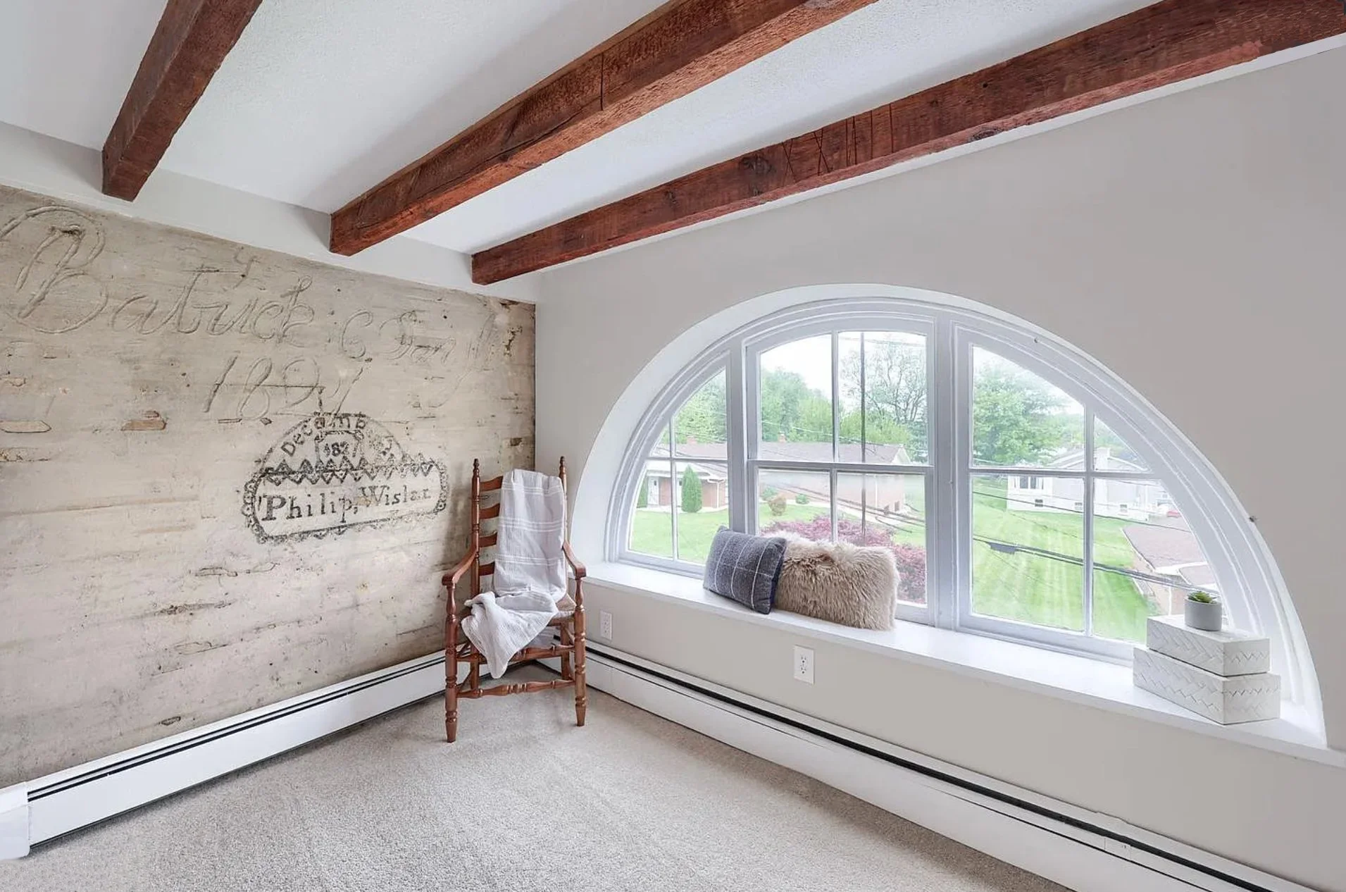 Bright room featuring a large arched window, neutral décor, and thoughtful styling in a professionally staged Columbia, PA home.