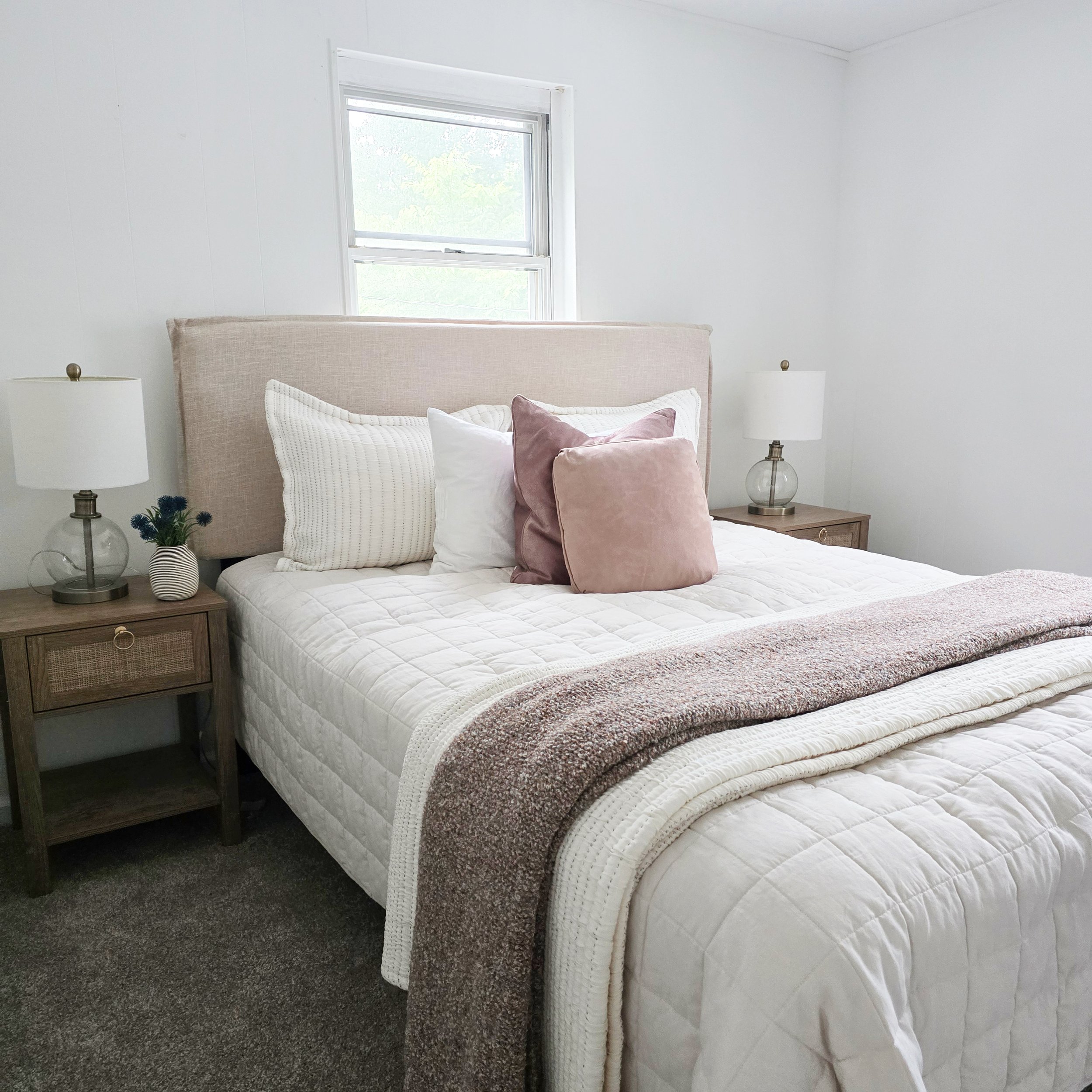 Close-up of a professionally staged bed featuring layered bedding, decorative pillows, and soft neutral textures in a South Central Pennsylvania home.