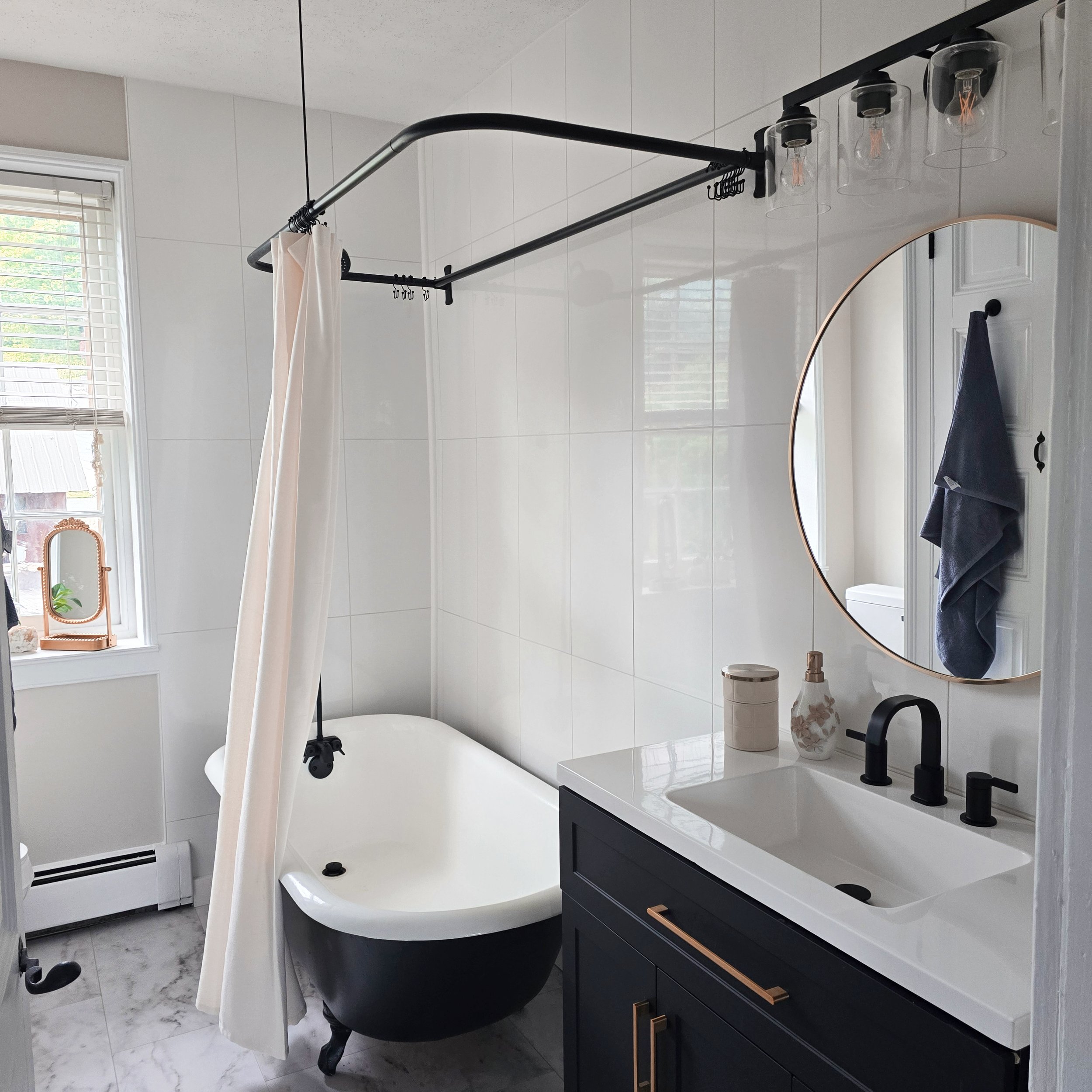 Professionally staged bathroom in a Columbia, PA Colonial Farmhouse featuring modern fixtures, a freestanding soaking tub, and bright natural light.