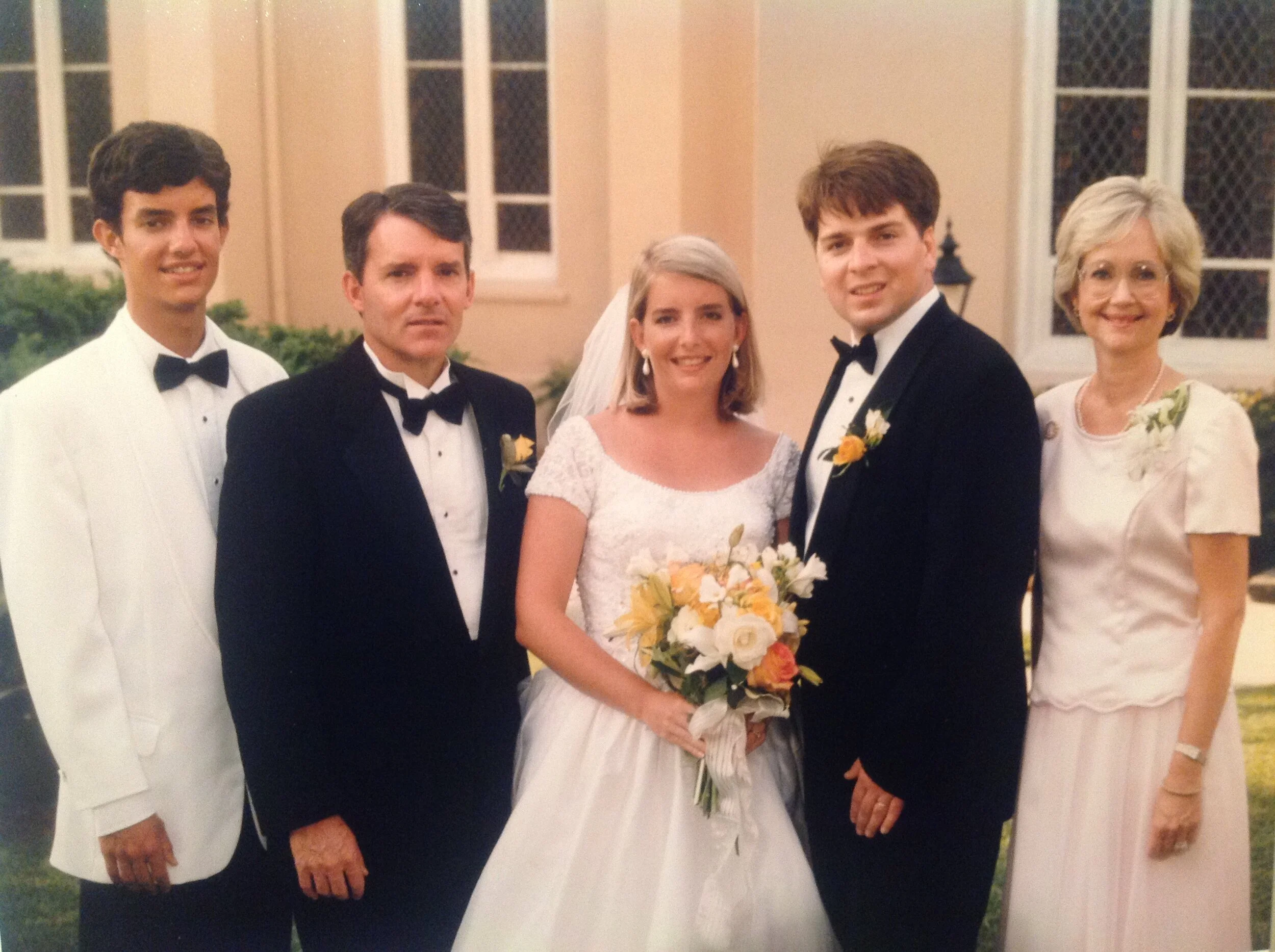 Son Taylor with Allison and John Farmer at their wedding with Marshall