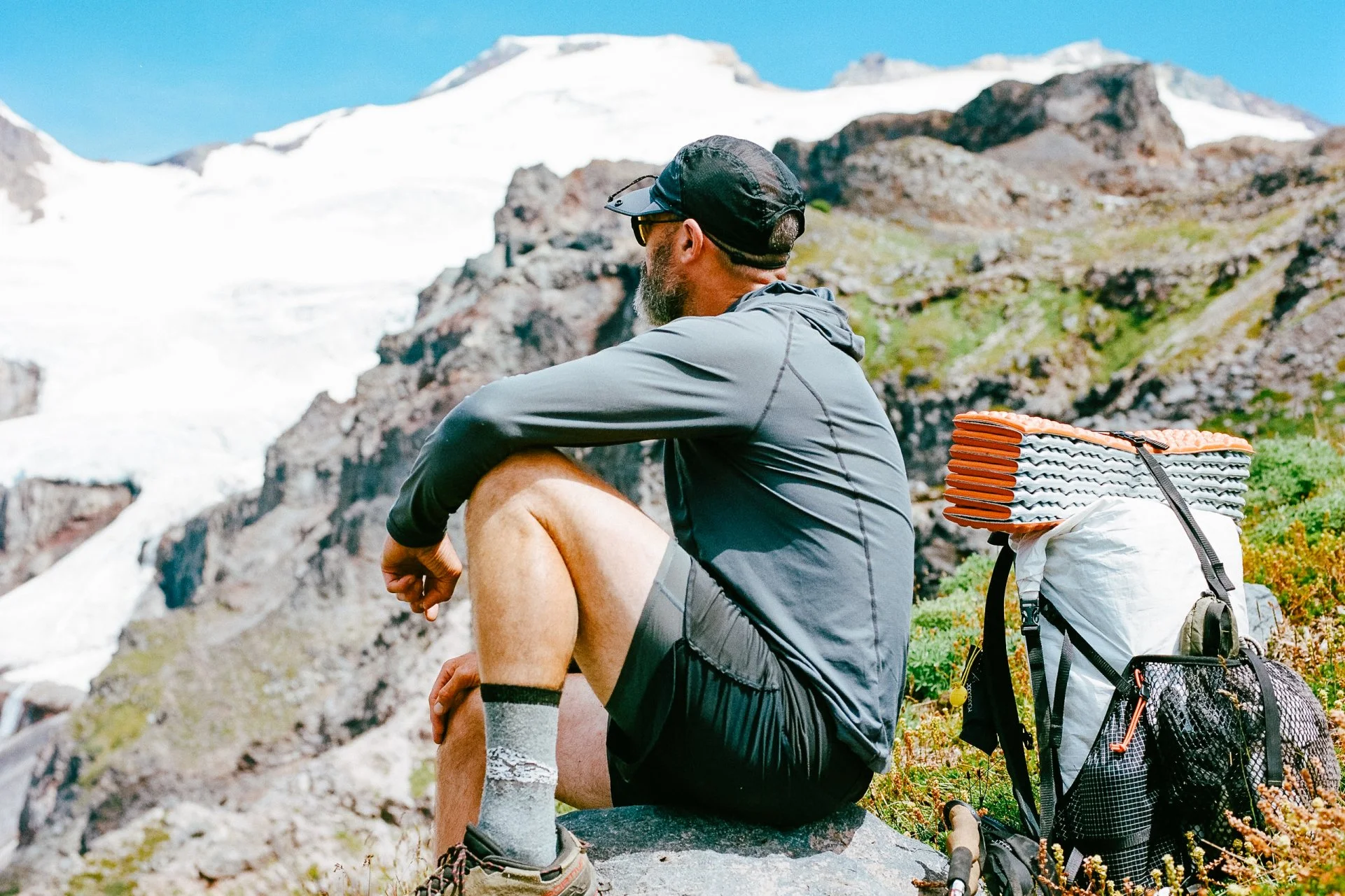 Parapack P-CAP LITE Jet Black on man resting in the high sierra mountain range, 5-panel sport cap, ultra lightweight, breathable mesh, compact, moisture wicking, unisex, UPF 50 headwear for travel, hiking, urban outdoors, photo by Jamie Cooper