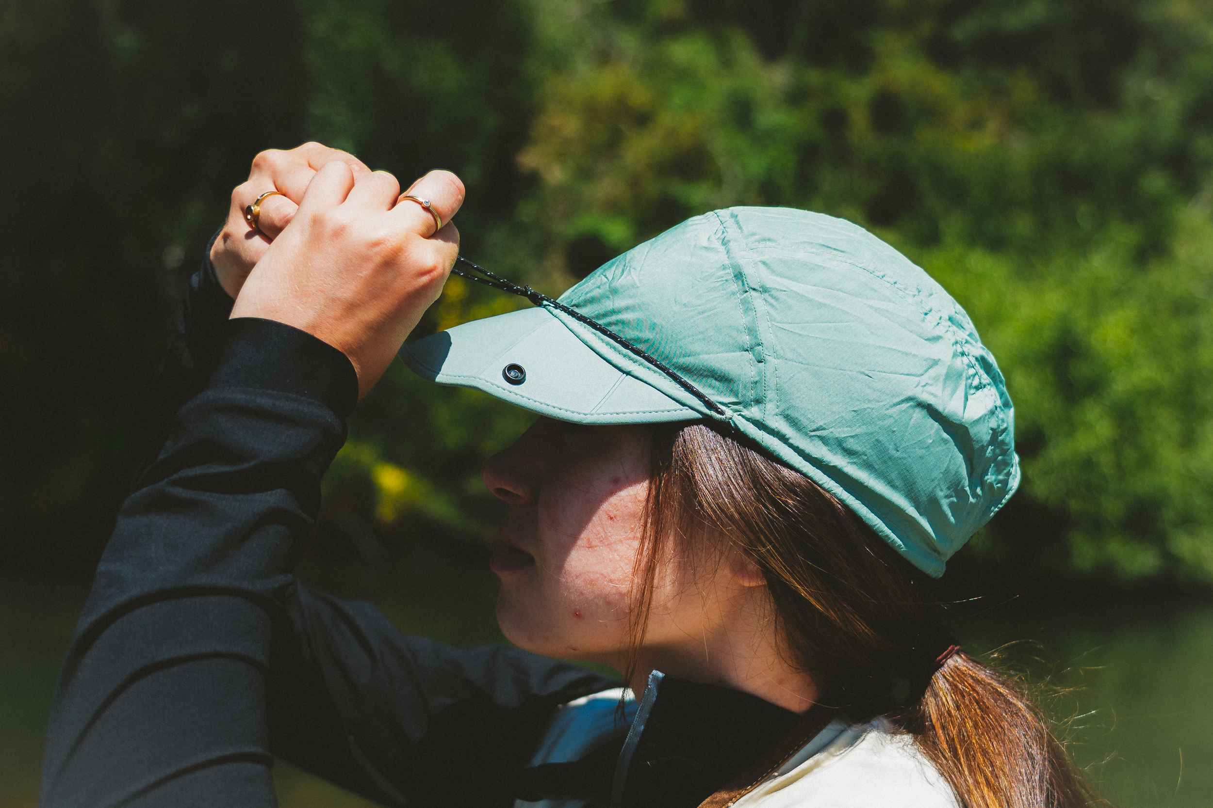 unique contemporary 5-panel style hat with snap and cord to keep hat compact for easy storage and size adjustment..