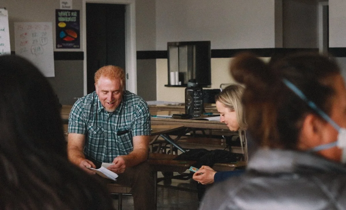 Educator talking with a student during a one-on-one conversation in a classroom