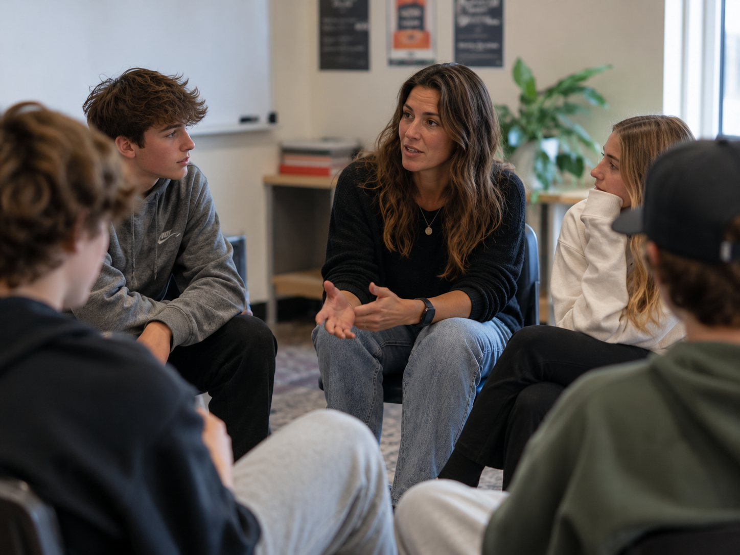 Middle and high school students sharing a genuine moment of laughter and connection during a classroom discussion, highlighting the importance of relationships and experiential learning in SEL curriculum.