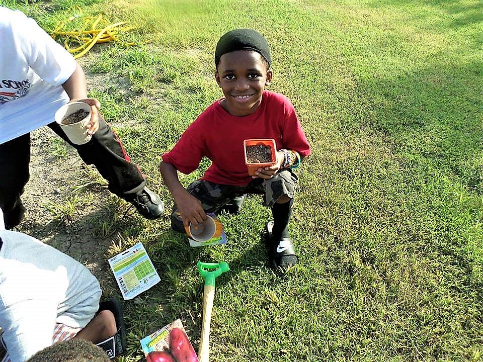 Little Boy Learns To Garden at Mississippi Youth Community Gardens Delta Gunnison.jpg