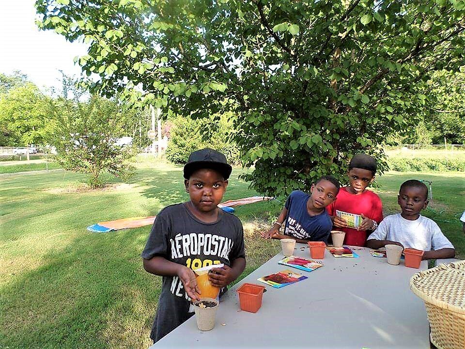 Children Around Table with Garden Seeds Mississippi Youth Community Gardens Gunnison.jpg