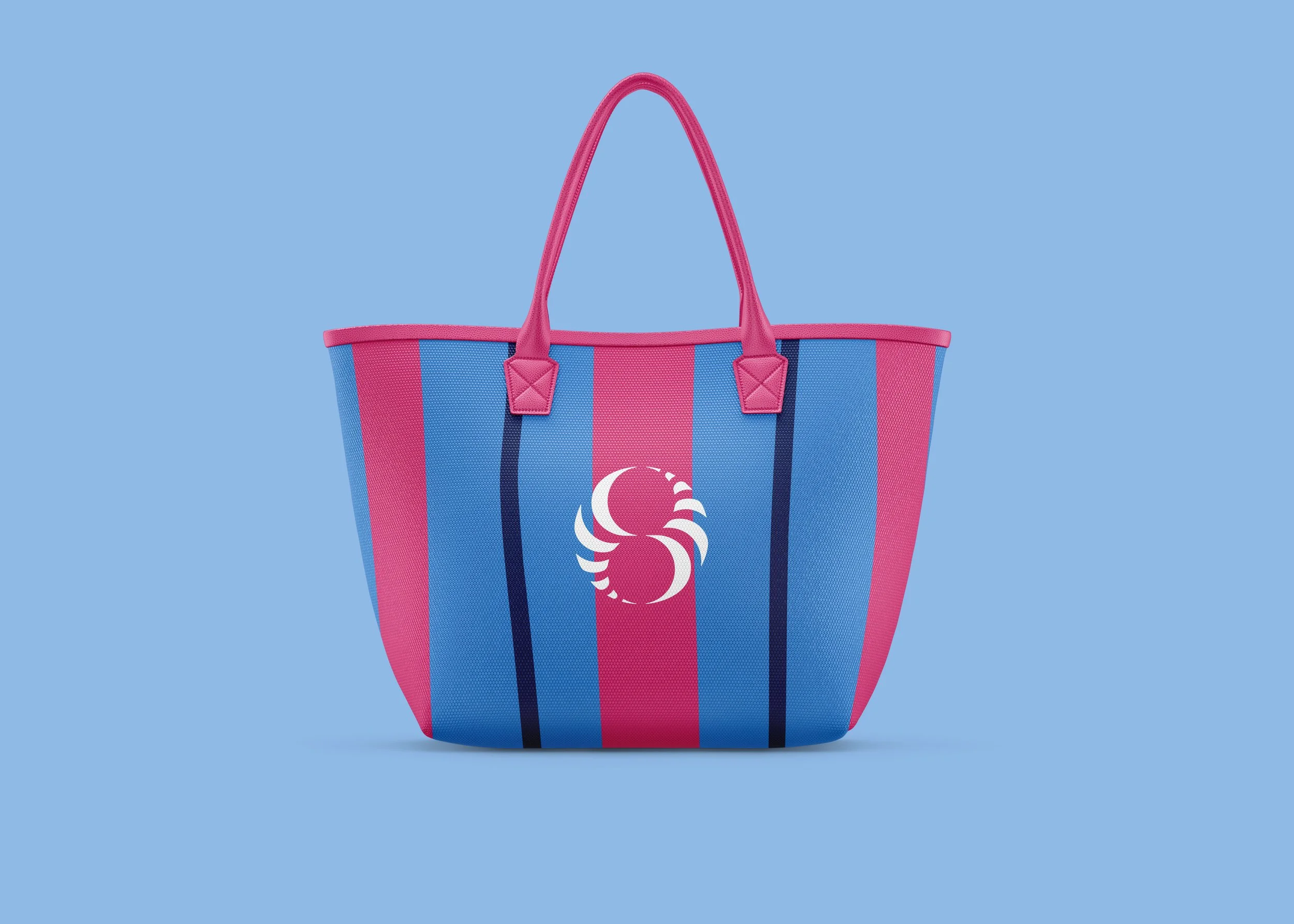 A colorful striped tote bag with pink handles and a pink and blue striped design, featuring a white swan logo on the front, set against a light blue background.