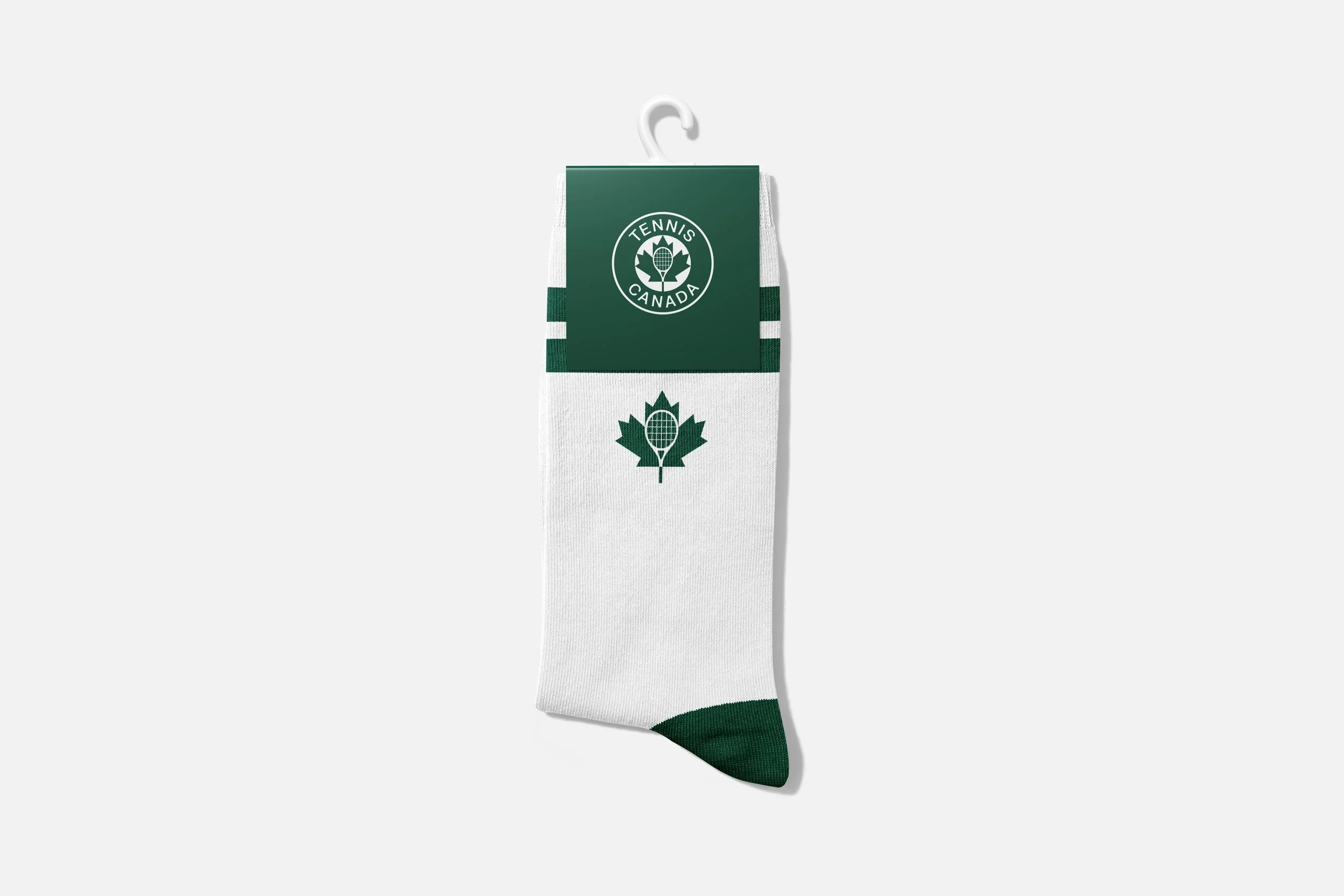 A white sock with green accents and the Tennis Canada logo, hanging on a plastic hook.