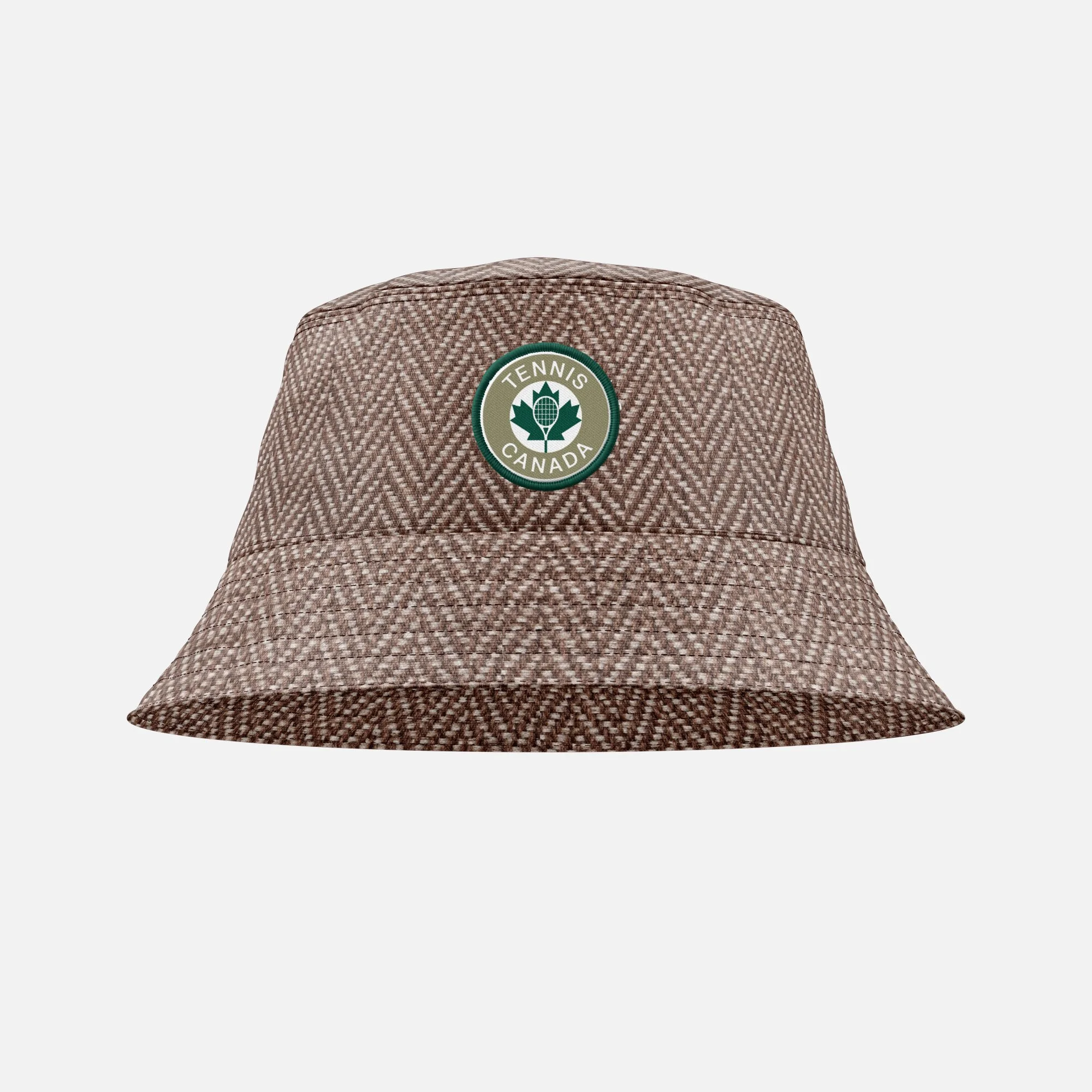 Close-up of a brown textured baseball cap with a green and white circular badge that reads "Tennis Canada".