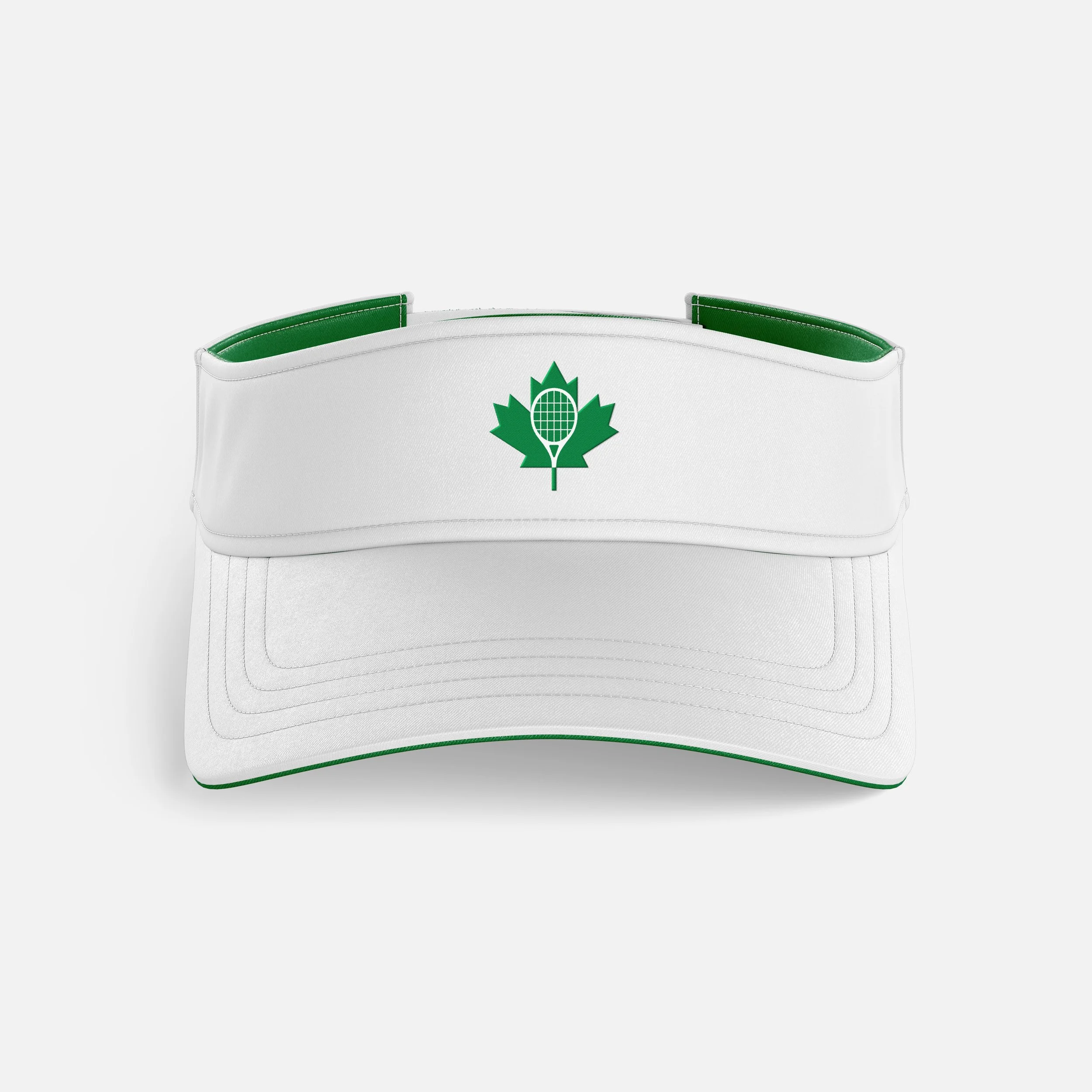 Close-up of a white hockey helmet with a green maple leaf logo on the front and green interior padding.