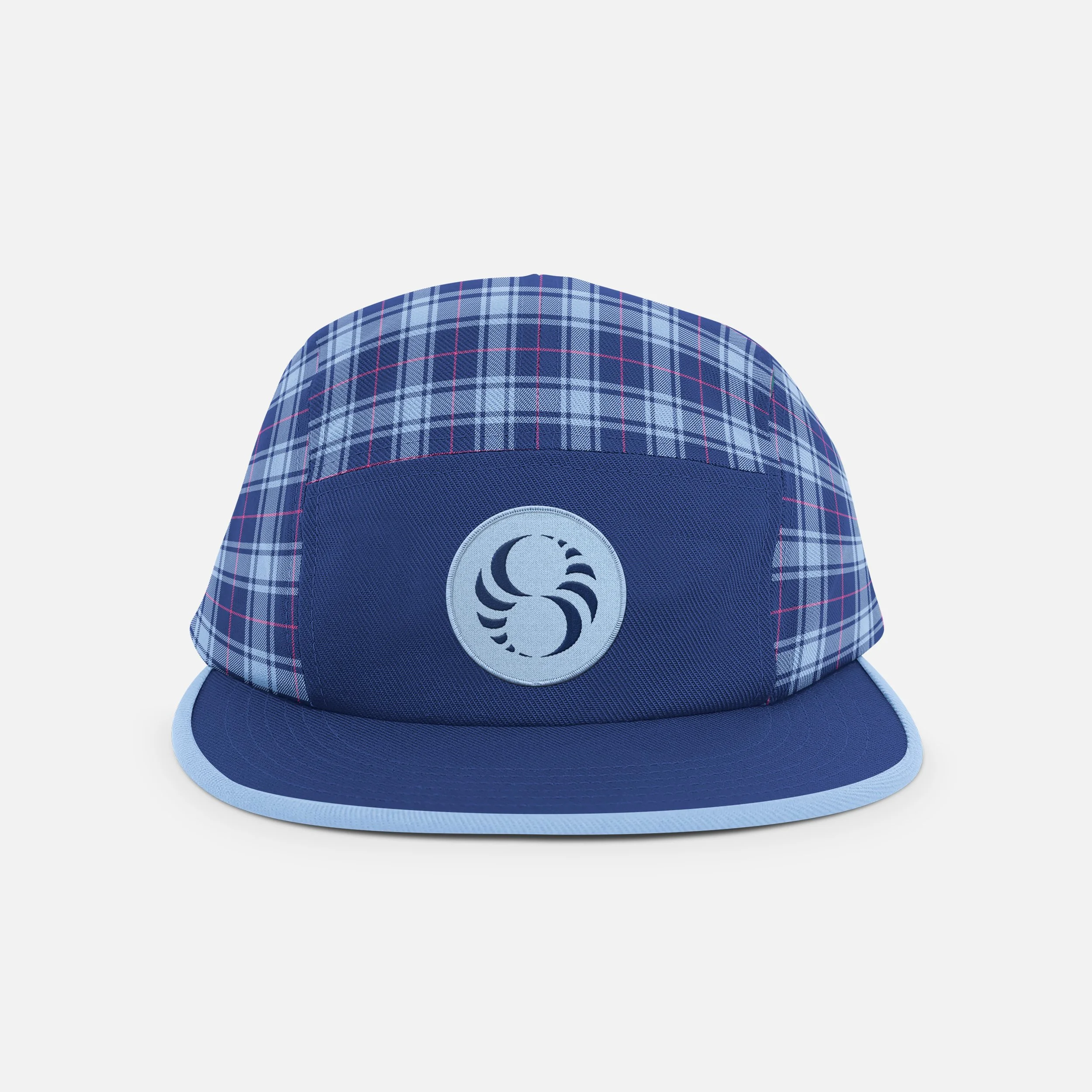 Blue baseball cap with a plaid pattern on the upper part and a circular logo featuring a sailing boat on the front