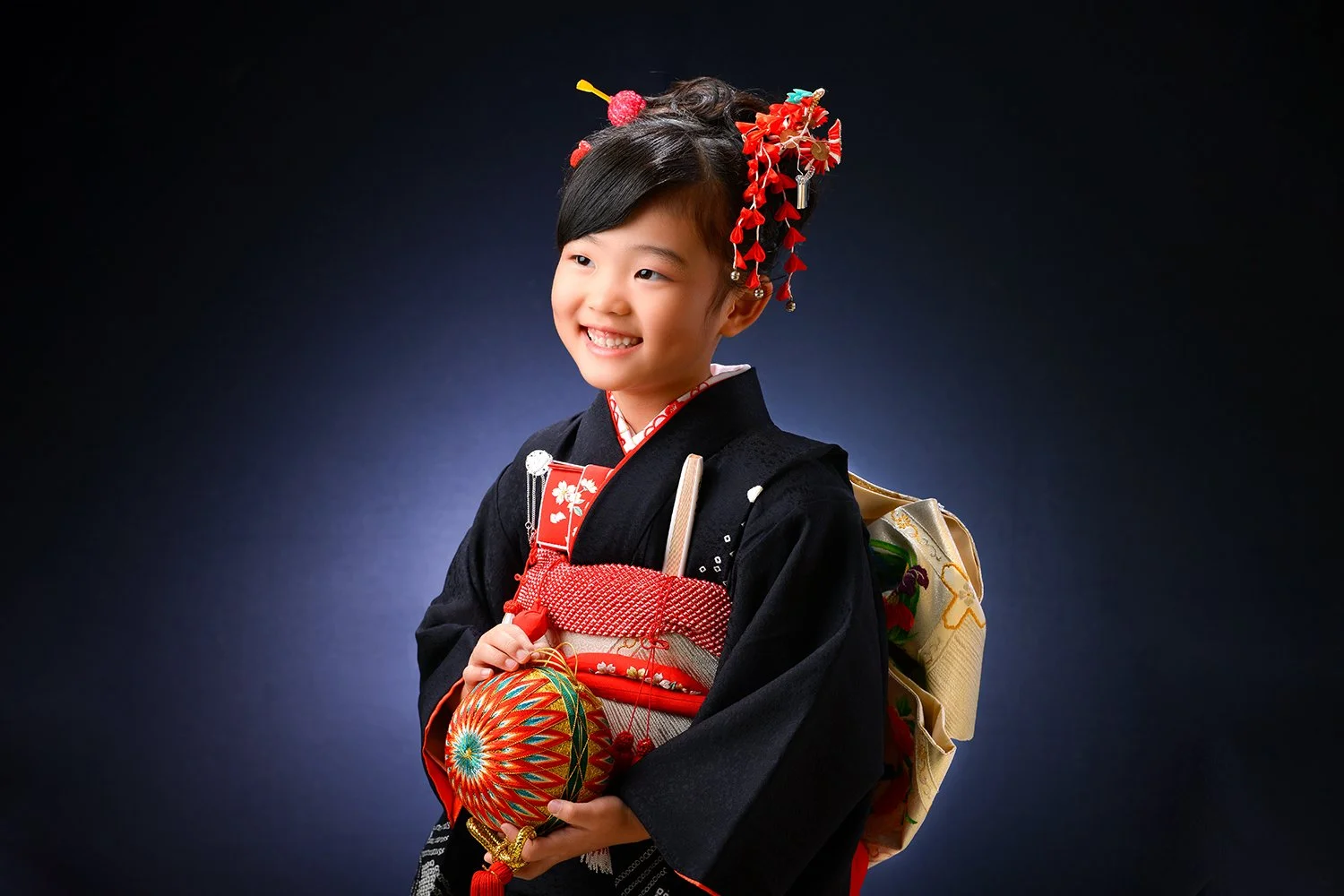 伝統的な着物を着た少女が笑顔でポーズをとっている写真