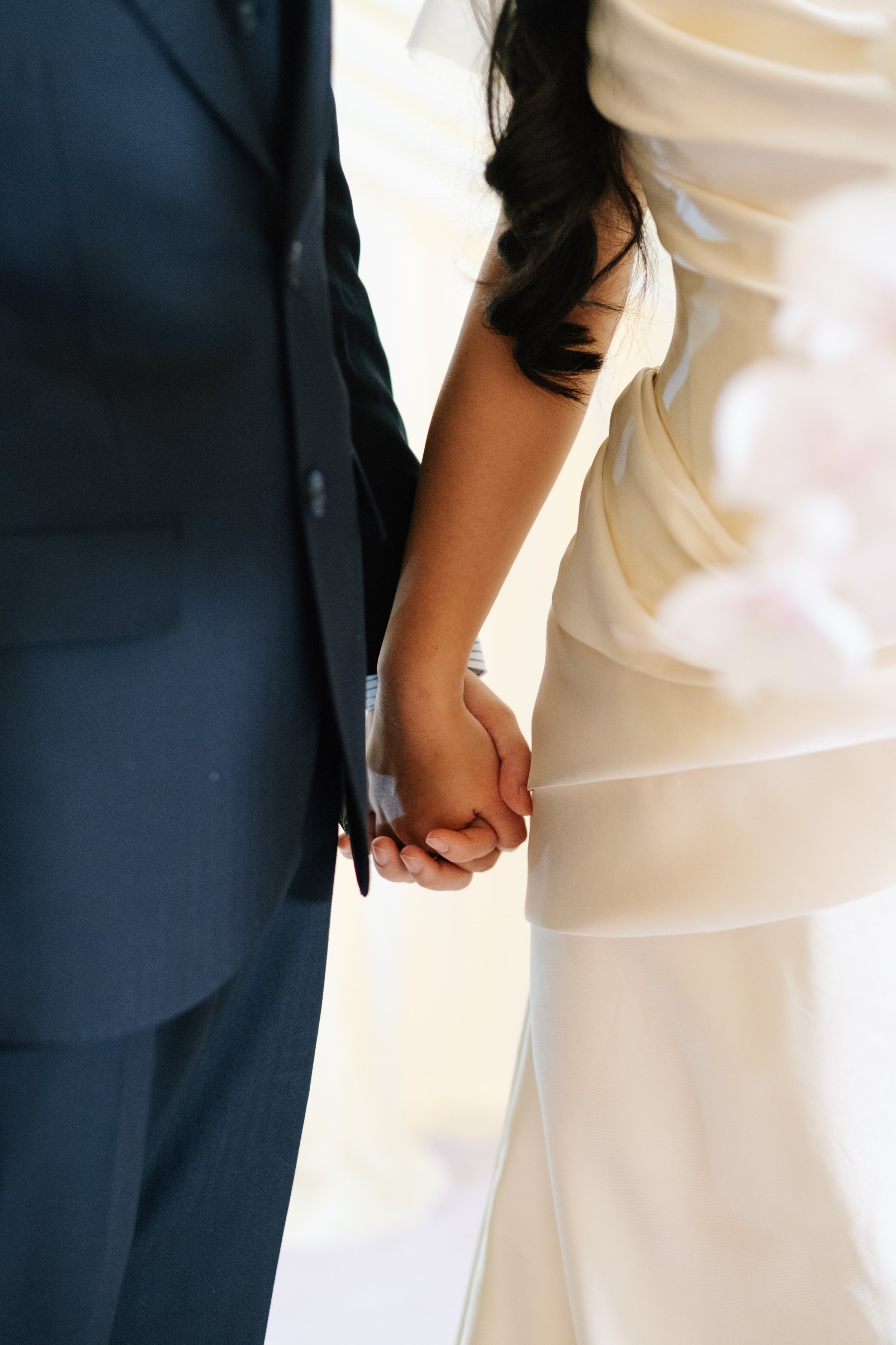 A bride and groom holding hands during their wedding ceremony.