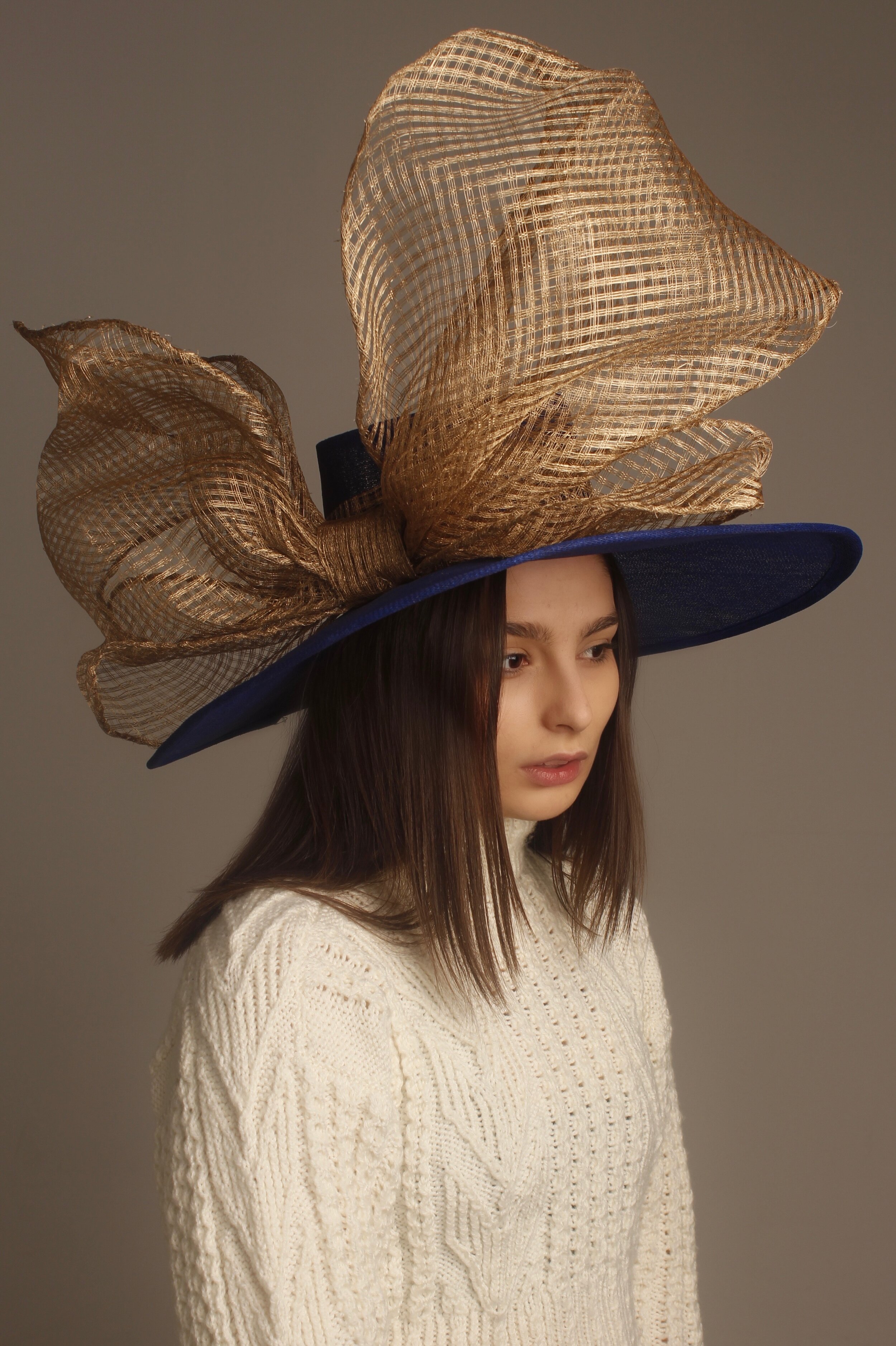 Both the brim and the crown were blocked. Once blocked, and unable to find the correct colour, I dyed the hat with oasis spray. For the headband, the gold sinamay was folded, so that no edges were visible, and hand sewn into the crown. For the bow, s