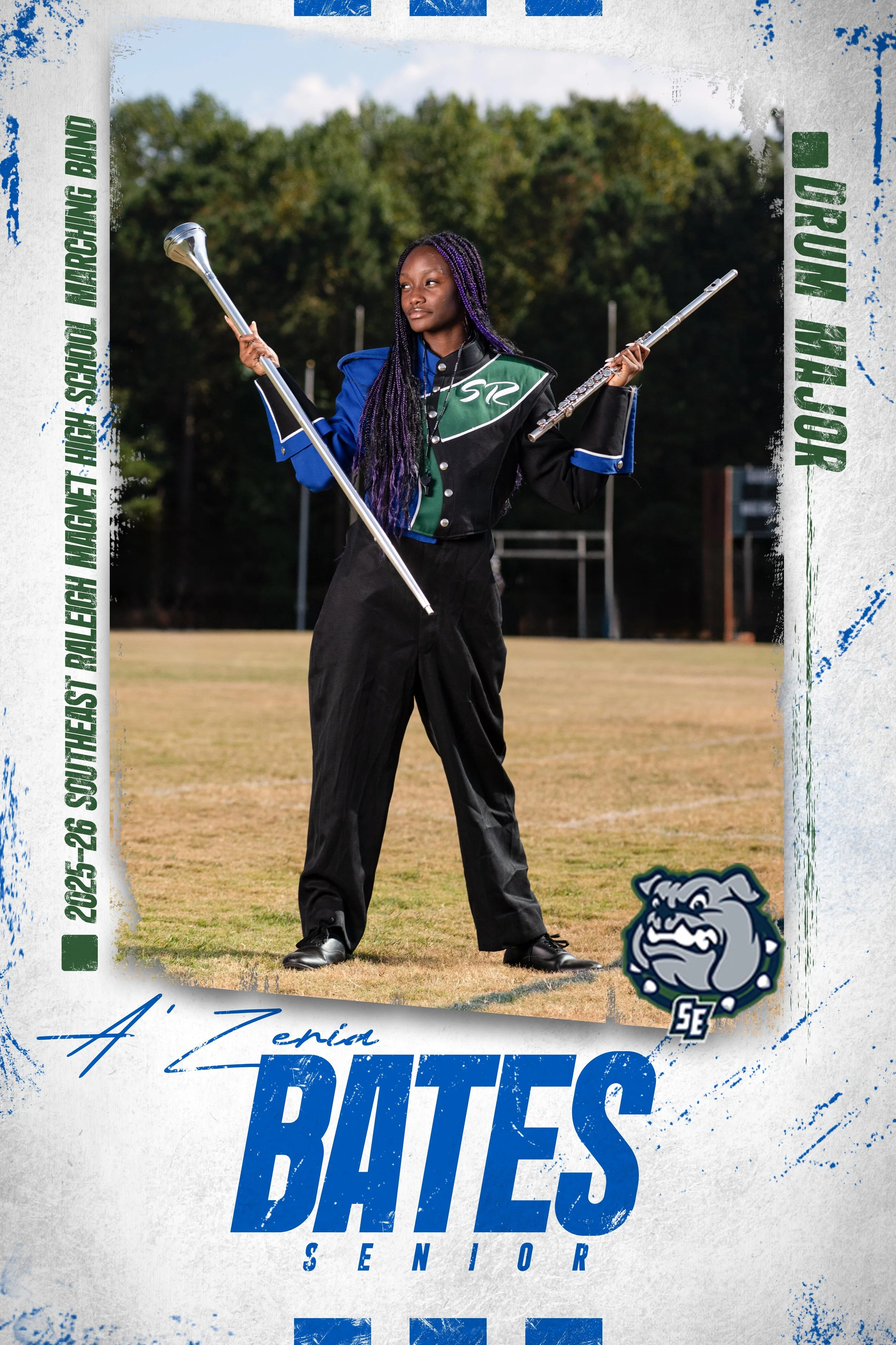 High school senior in band uniform holding a flag and a flute on a sports field, with trees in the background, celebrating her senior year.