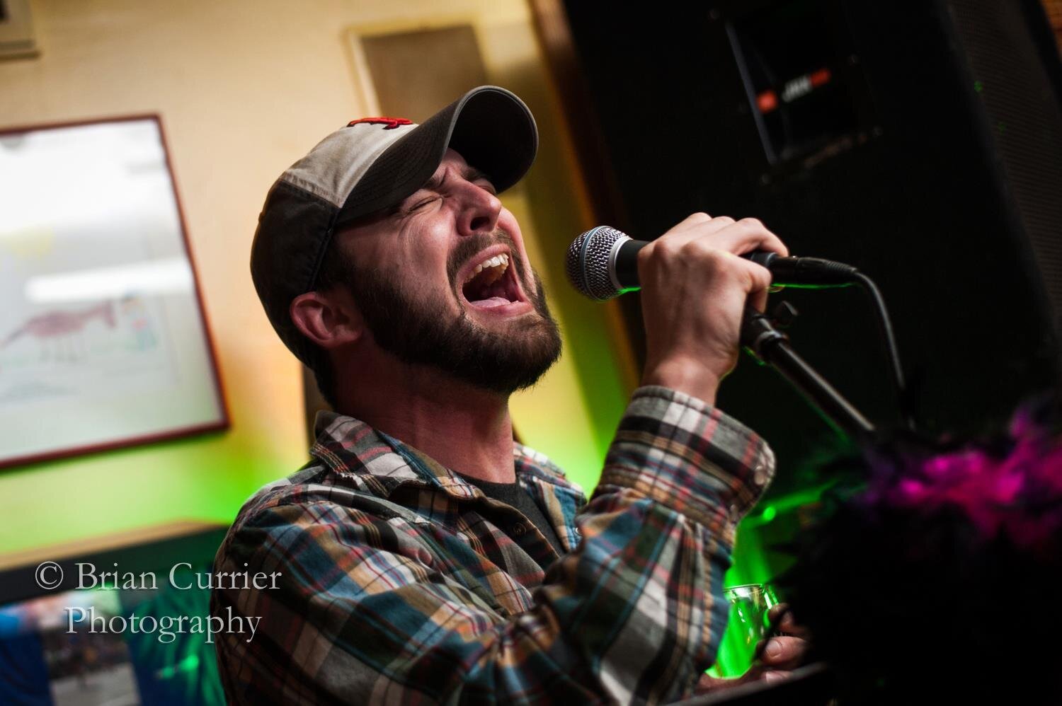 Tim belts out a song on stage with friends.