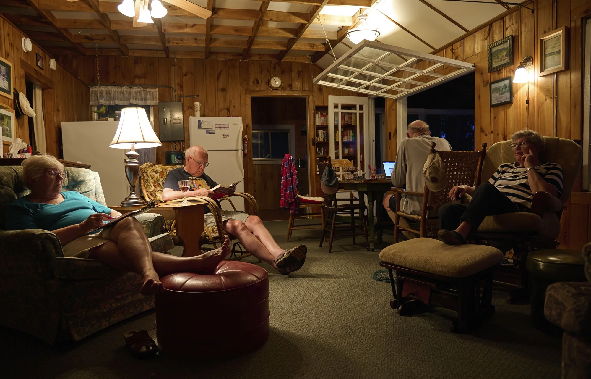 Two older women and two older men sitting in a dimly lit living room at night