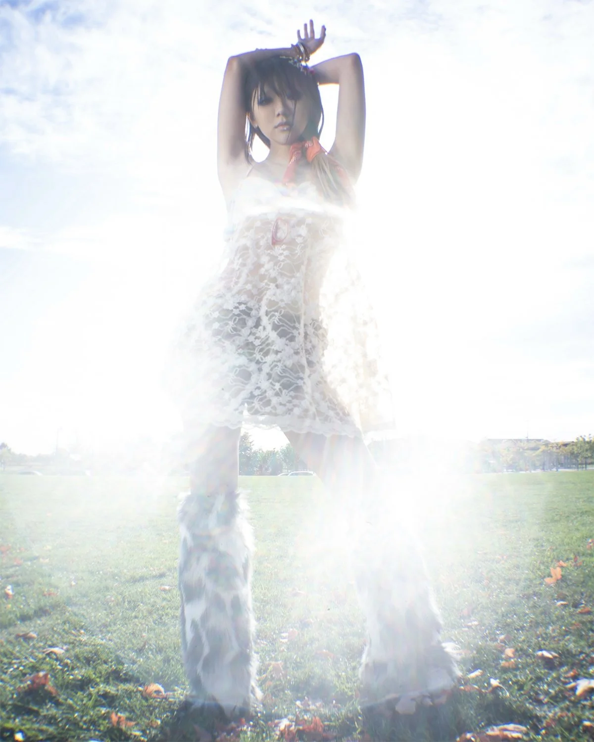 girl standing on grass in bright sunlight wearing a lace dress