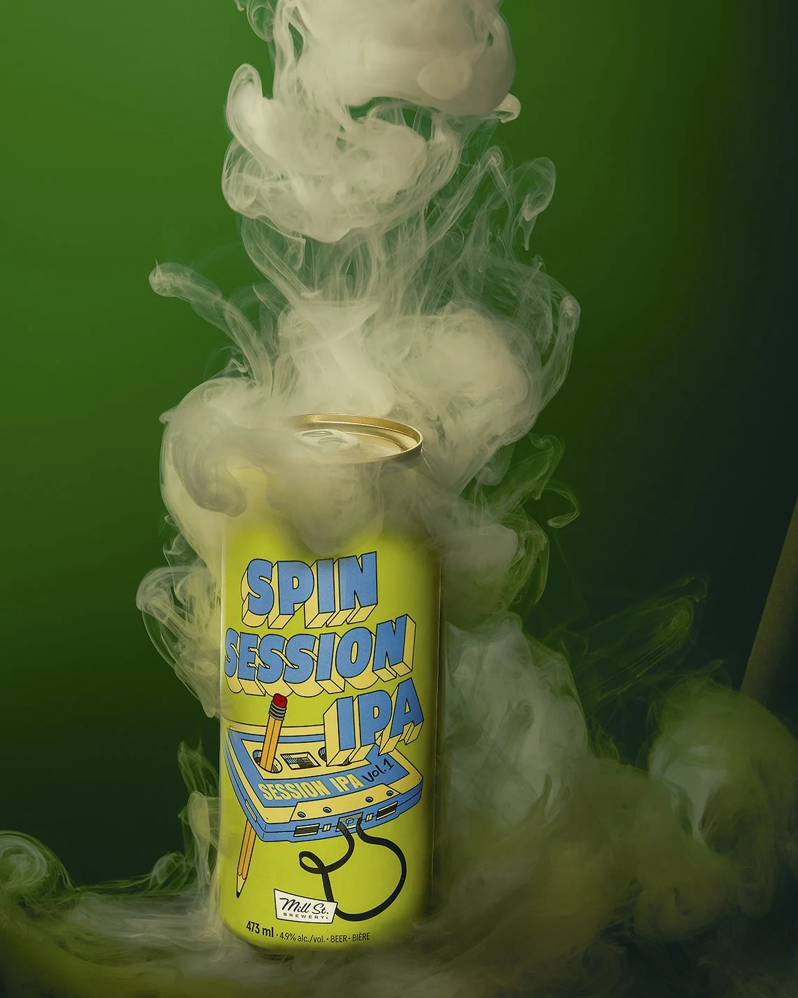Green beer can with light blue writing. Swirling smoke around the can. High contrast lighting on green background