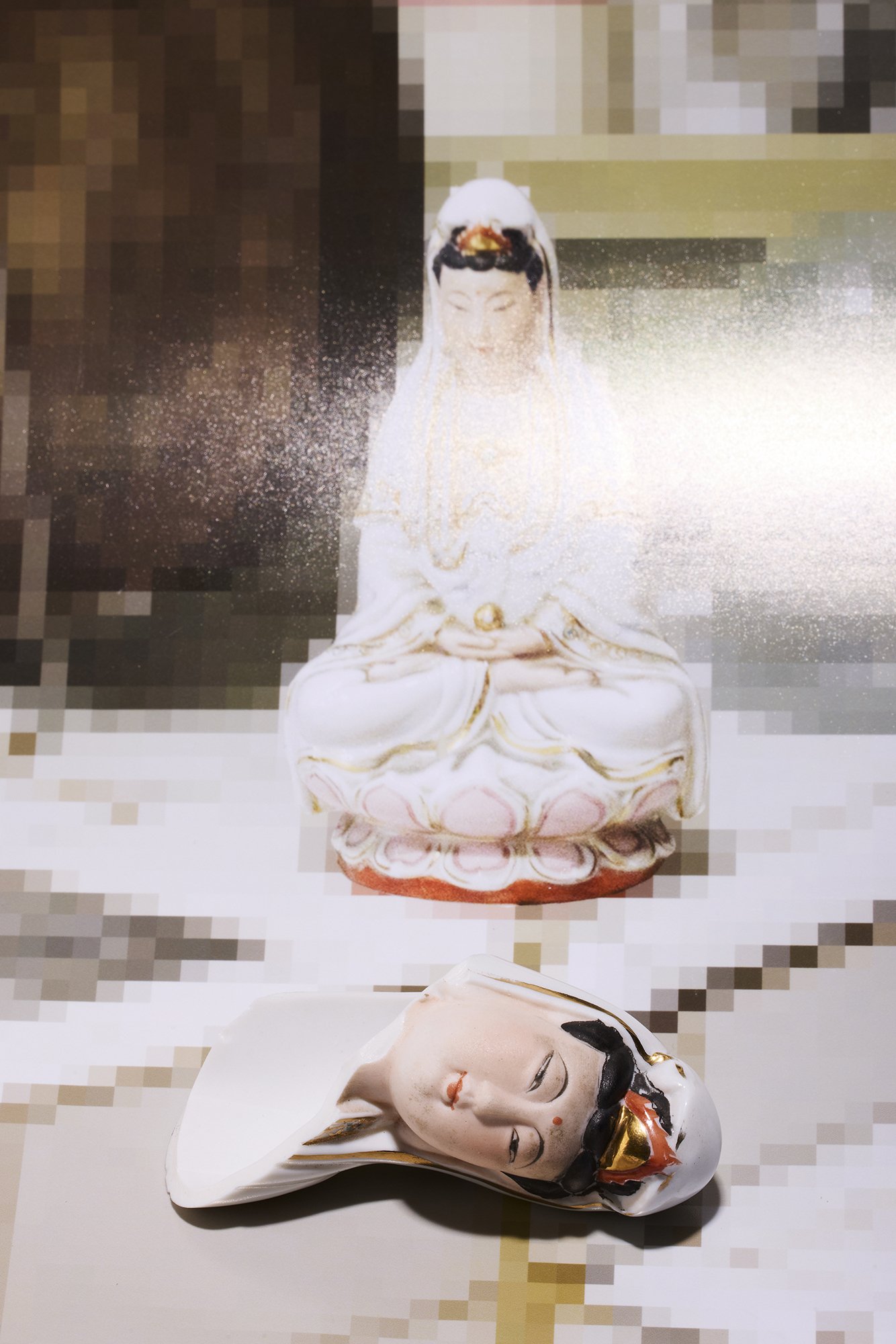 White statue above a porcelain broken statue head on floor