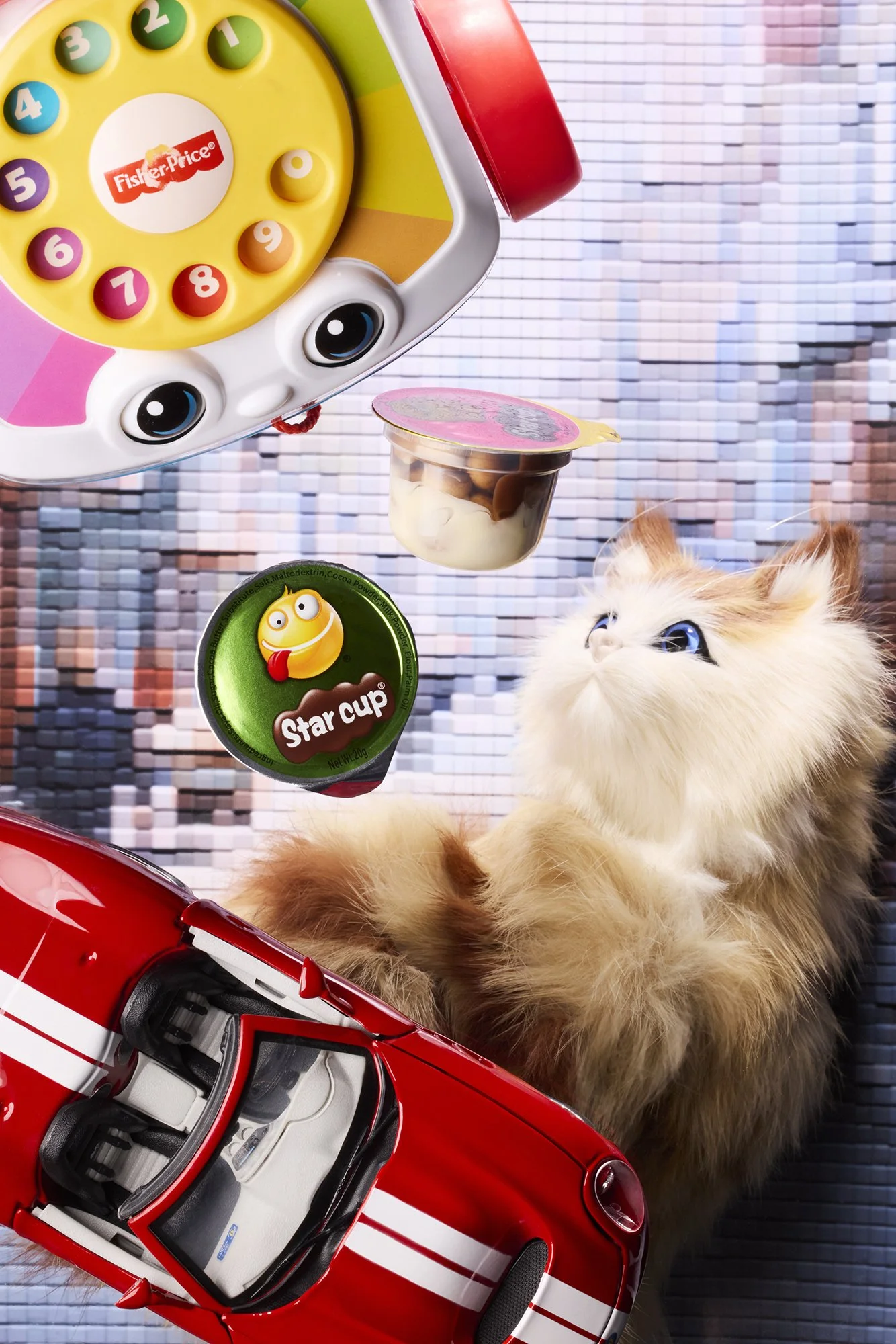 Flurry toy cat placed under toy phone, cups and red car