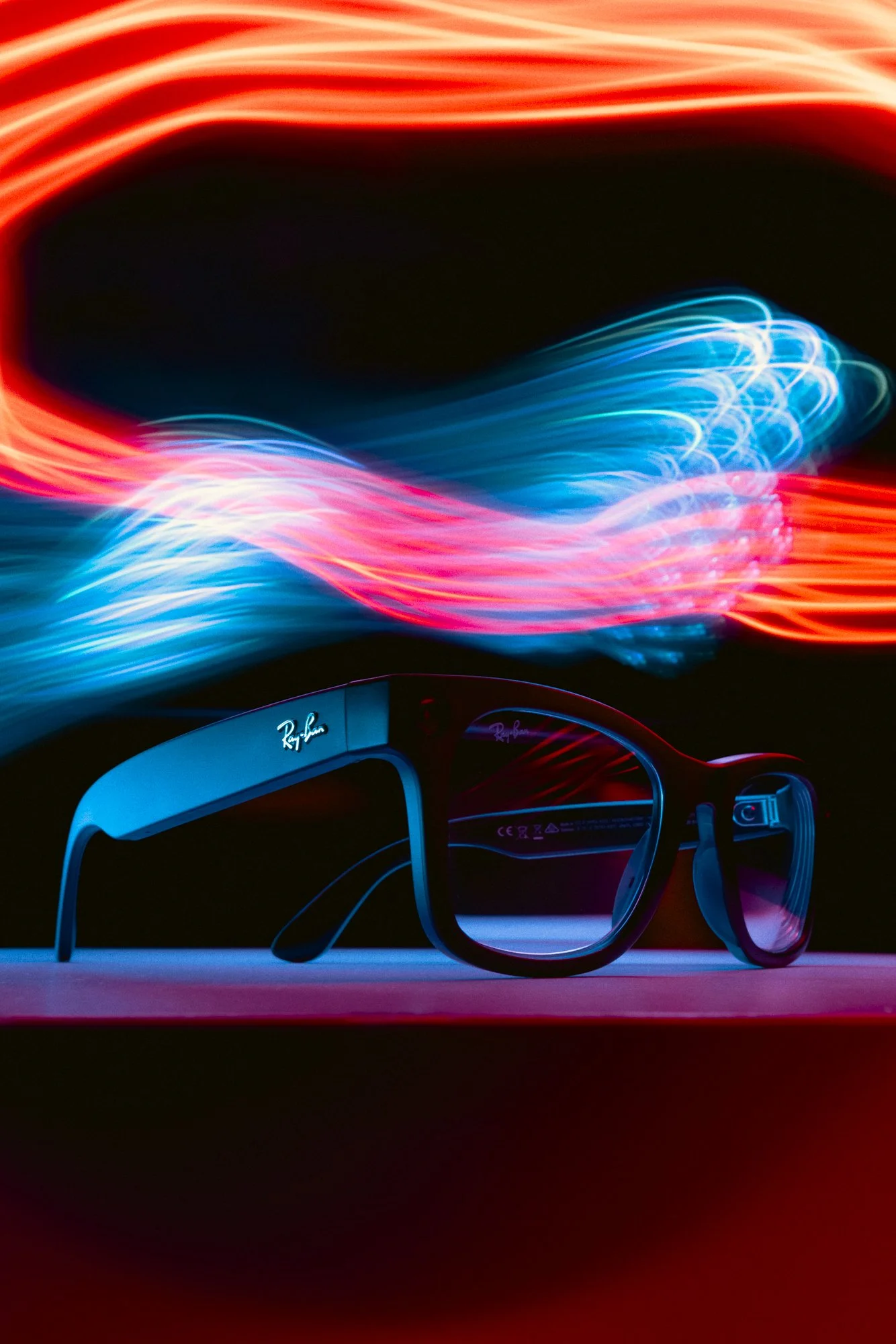 Black sunglasses with red and blue light trails flowing overhead.