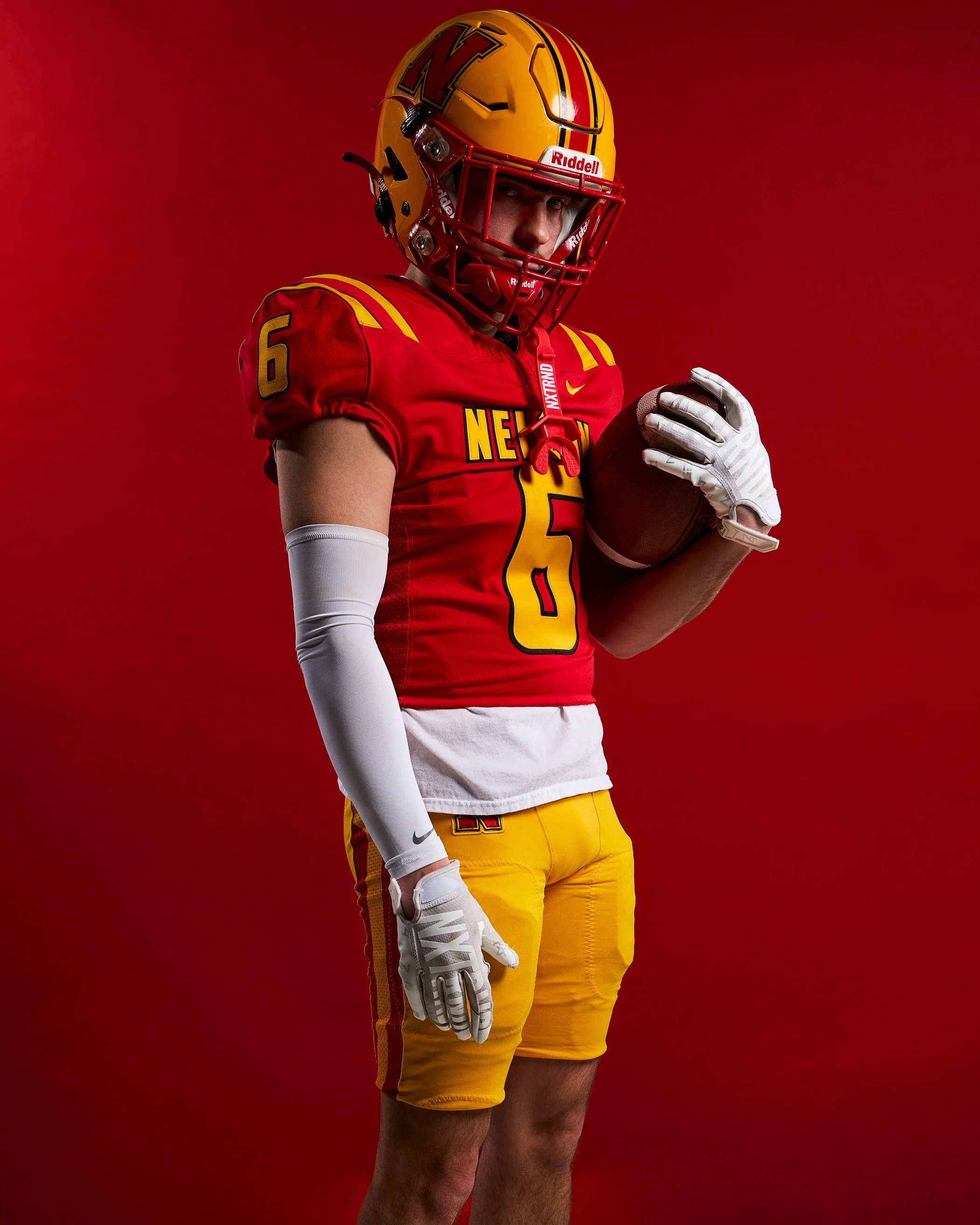 Football team facing field in foggy sky with jersey numbers and back facing the camera