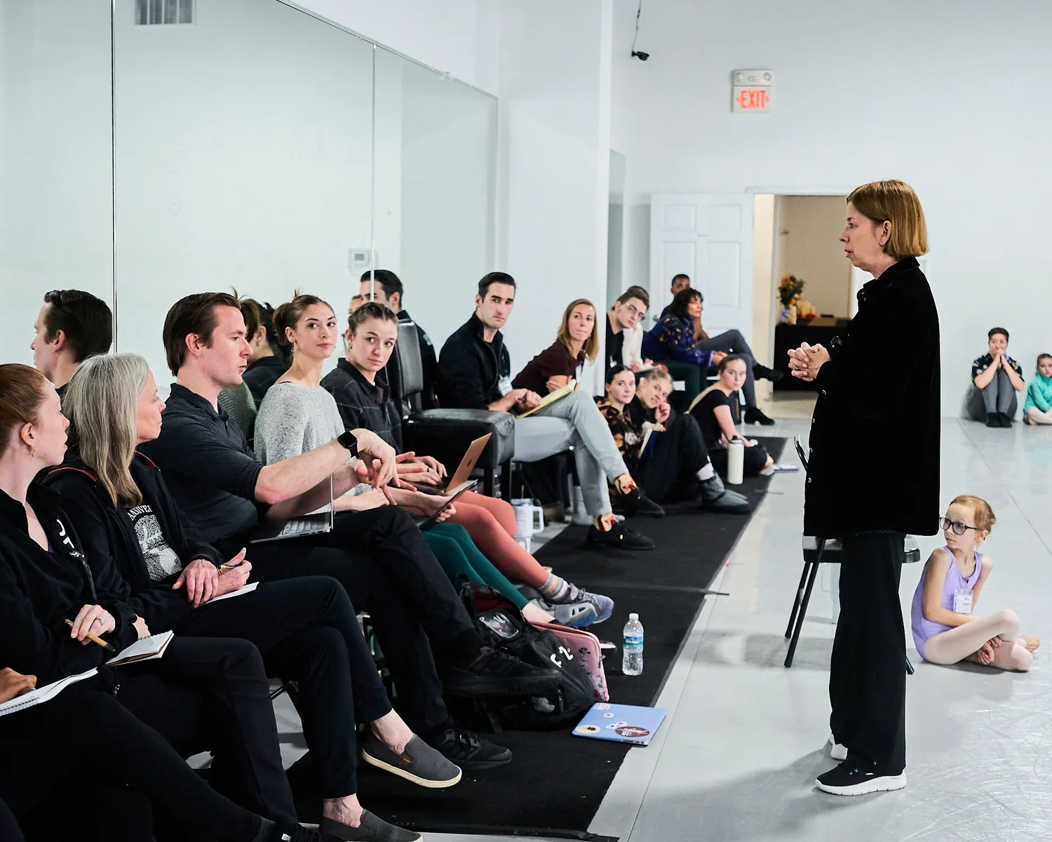 Workshop participants listening as an instructor speaks in a Ballet 5:8 studio