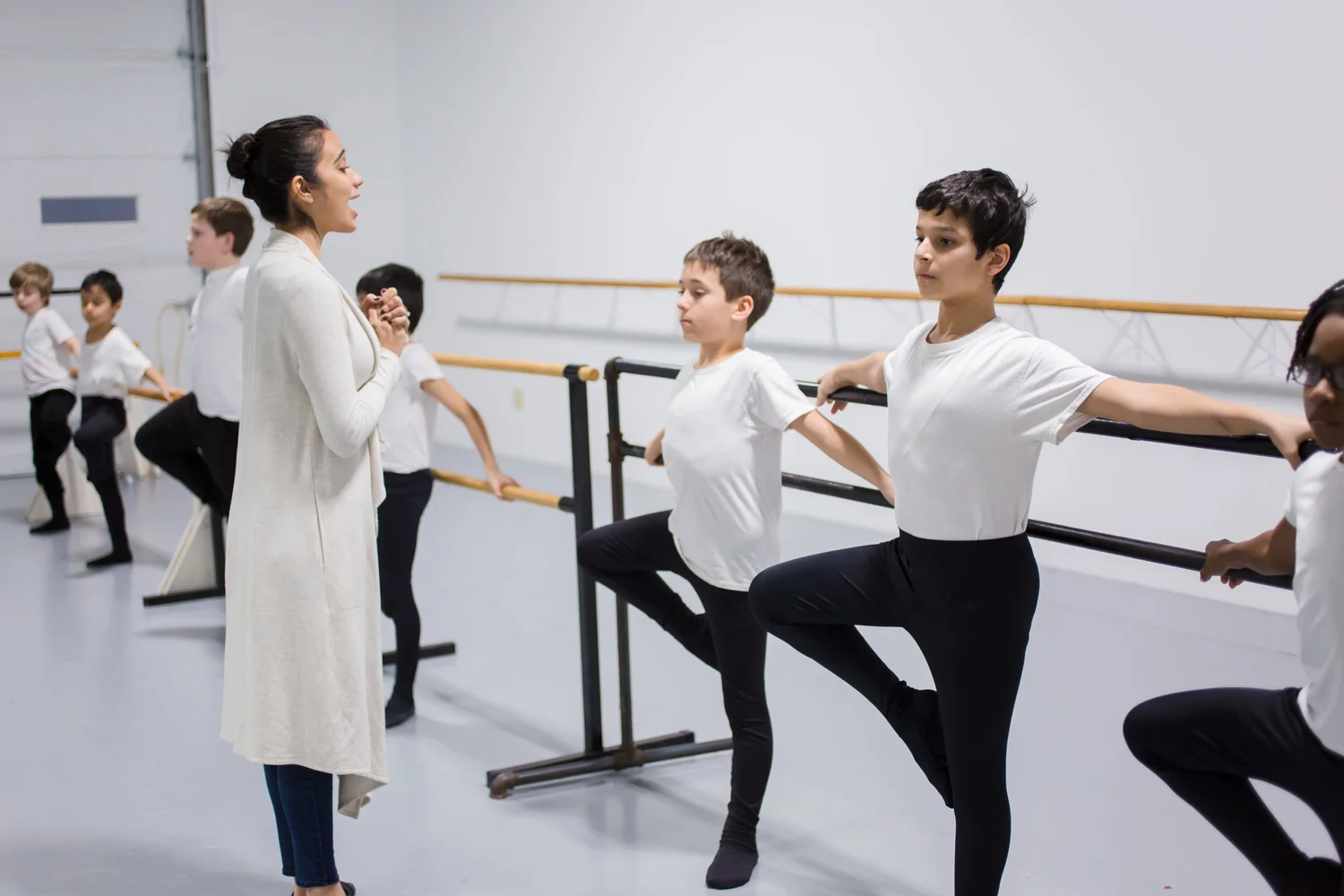 A Ballet Five Eight instructor guiding students at the barre