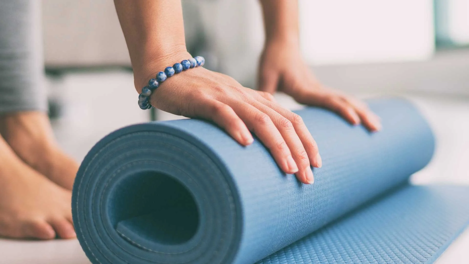 Woman with a yoga mat at Restore Studio in Annapolis