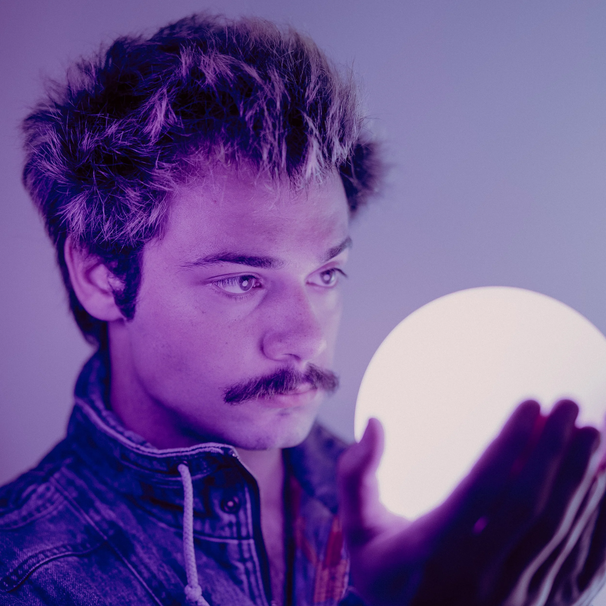 Musician and content creator "Ellit" holding a glowing orb, an alternative photo from his "Endure" album photoshoot