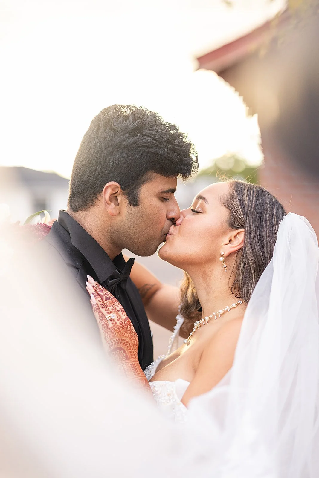 bride and groom kissing at sunset