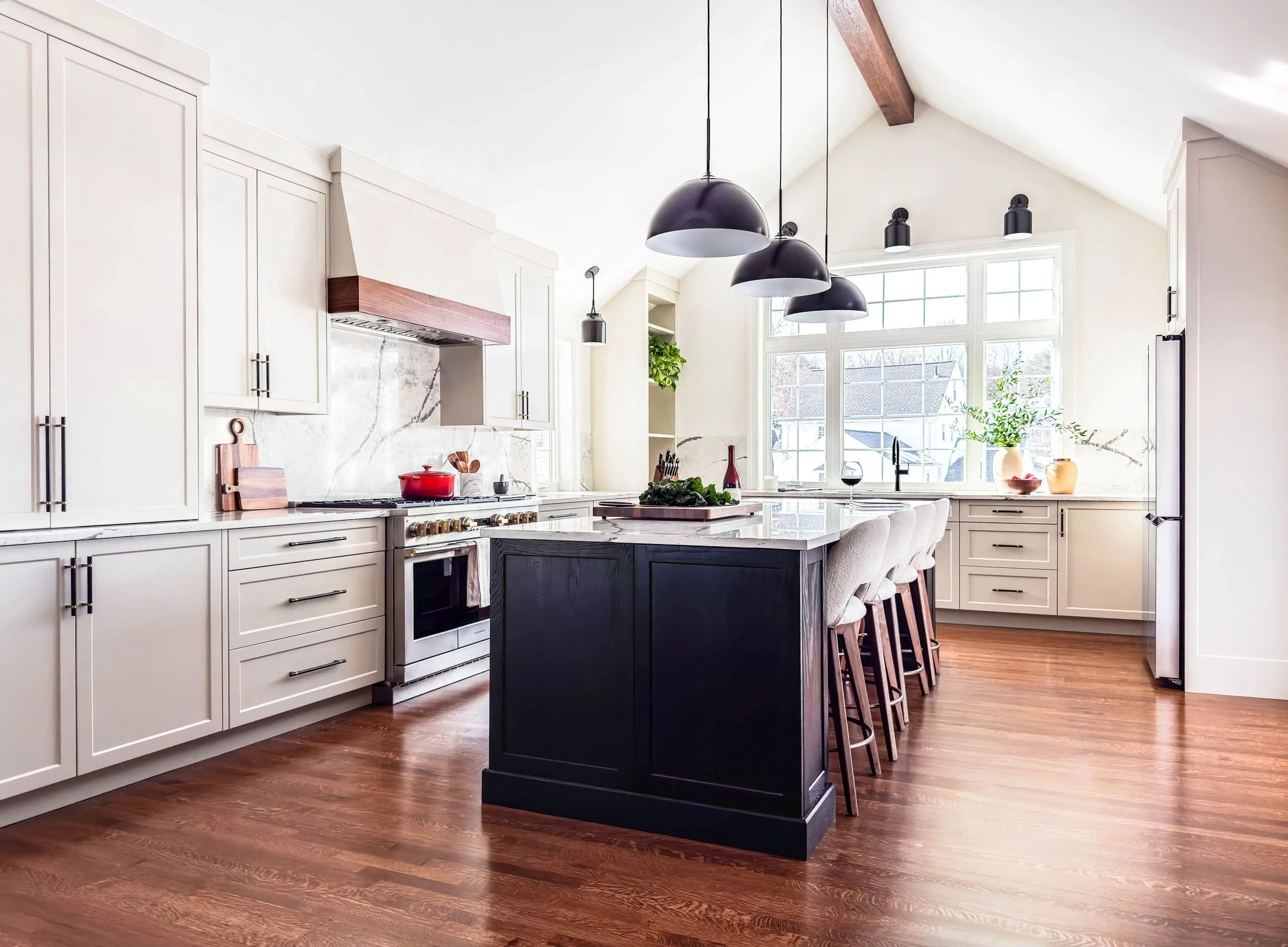 Overall view of completed vaulted kitchen addition with beige cabinetry and stained black oak island.
