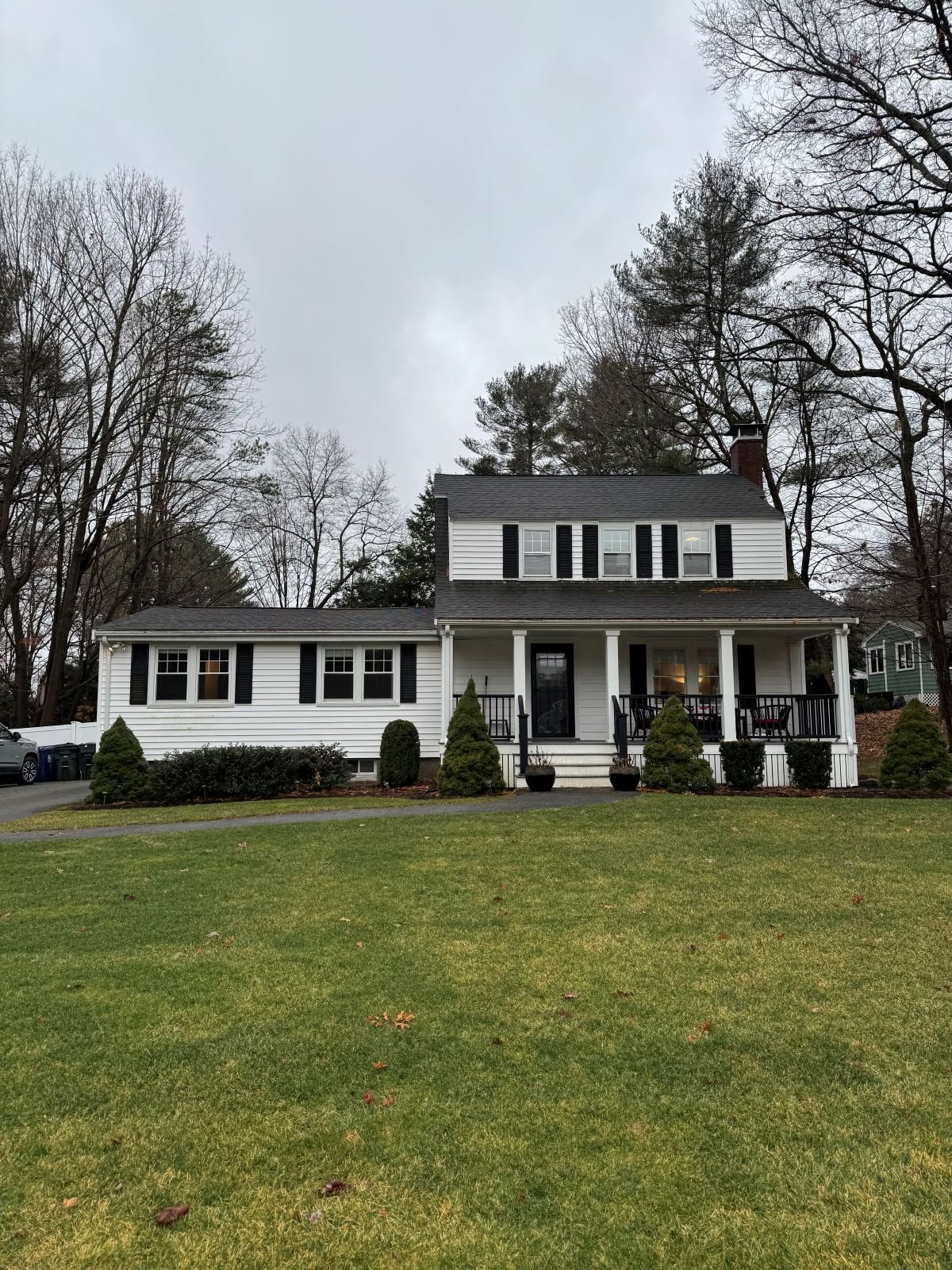 Existing street view of a Dutch Colonial home in Greater Boston prior to second story addition showing original scale and massing before renovation by Tact and Grit Design Co.