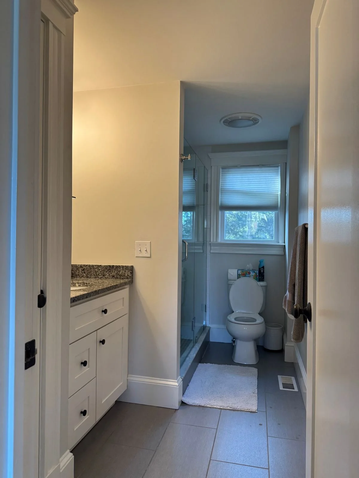 Existing primary bathroom of a Dutch Colonial home in Greater Boston prior to second story addition showing original vanity, tile floors and layout