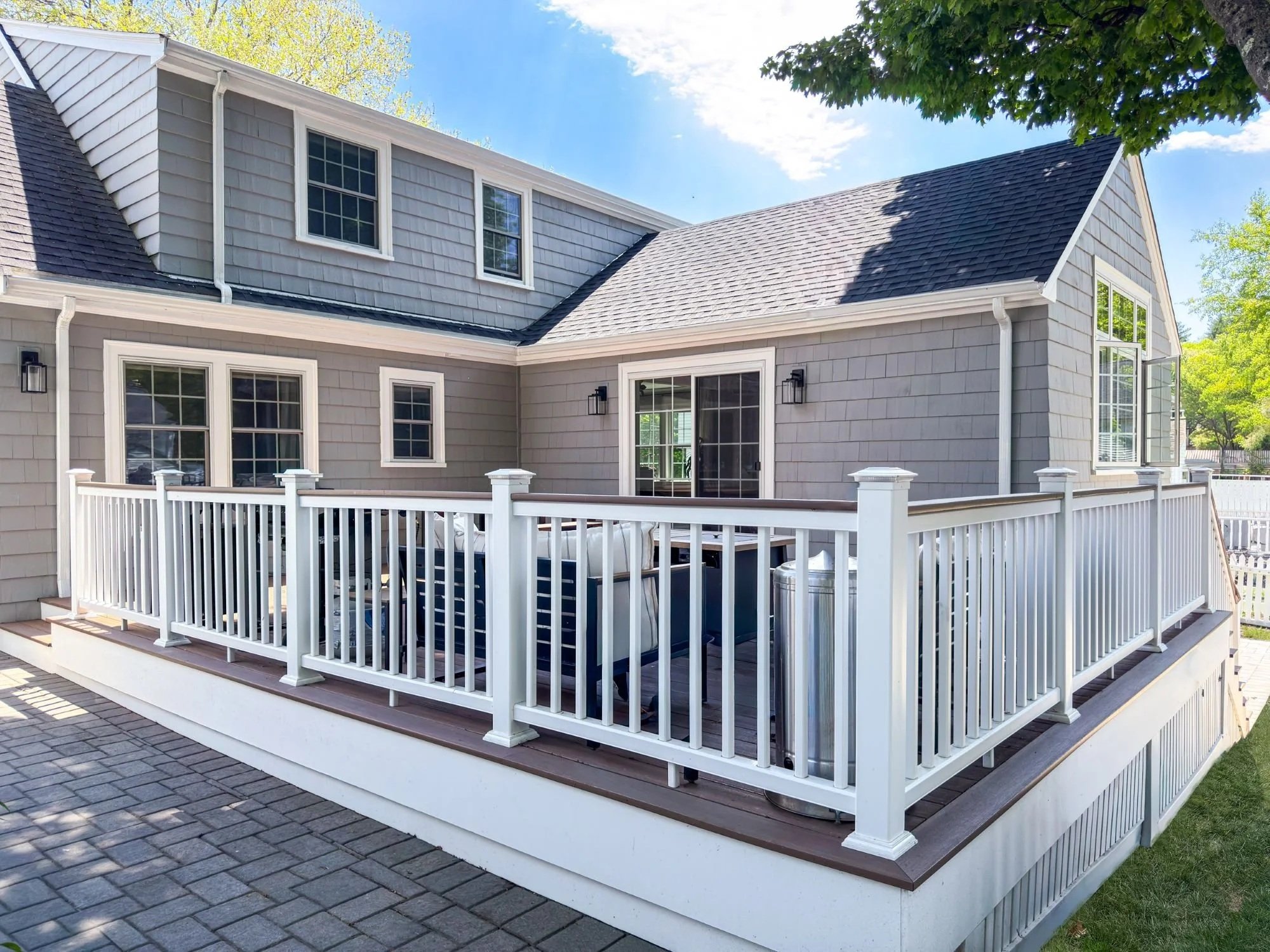 New rear deck with timber tech decking and drink rail on a colonial home addition in Melrose, MA designed by Tact and Grit Design Co.
