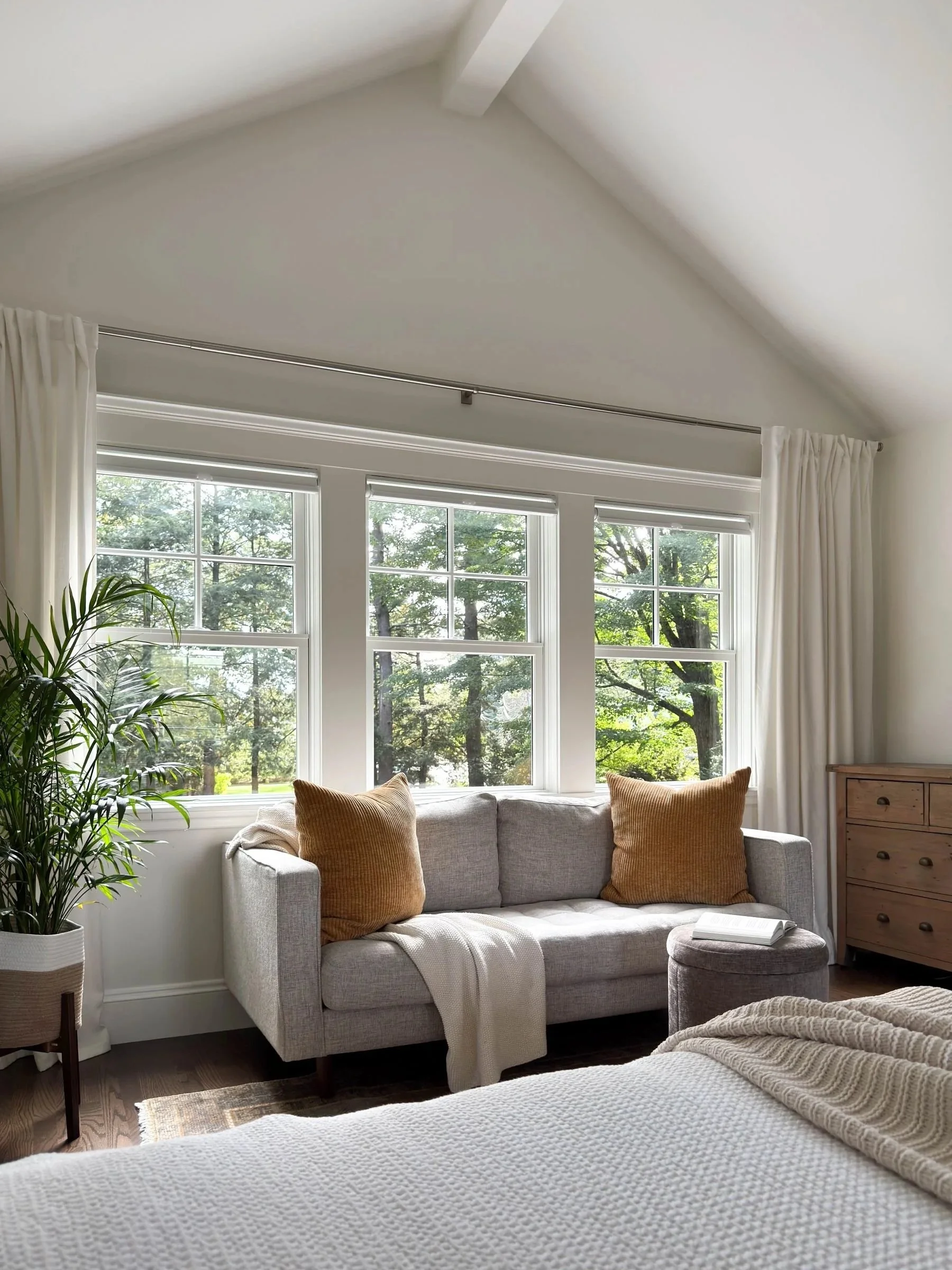Completed reading lounge of a Dutch Colonial primary suite addition in Greater Boston showing triple window array with backyard views and natural light designed by Tact and Grit Design Co.