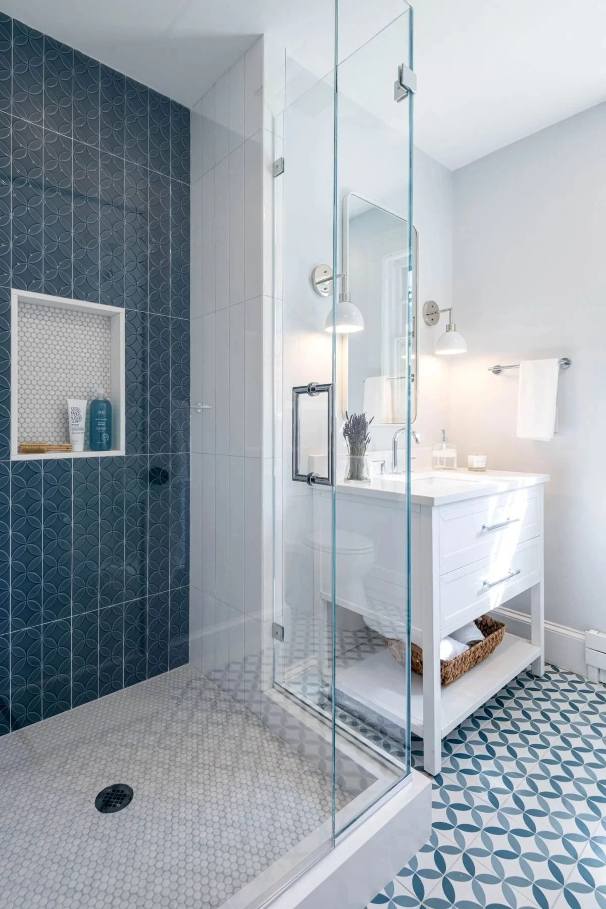 A modernized secondary bathroom in Medford, MA, featuring bold geometric circular tile and an airy, reconfigured layout.