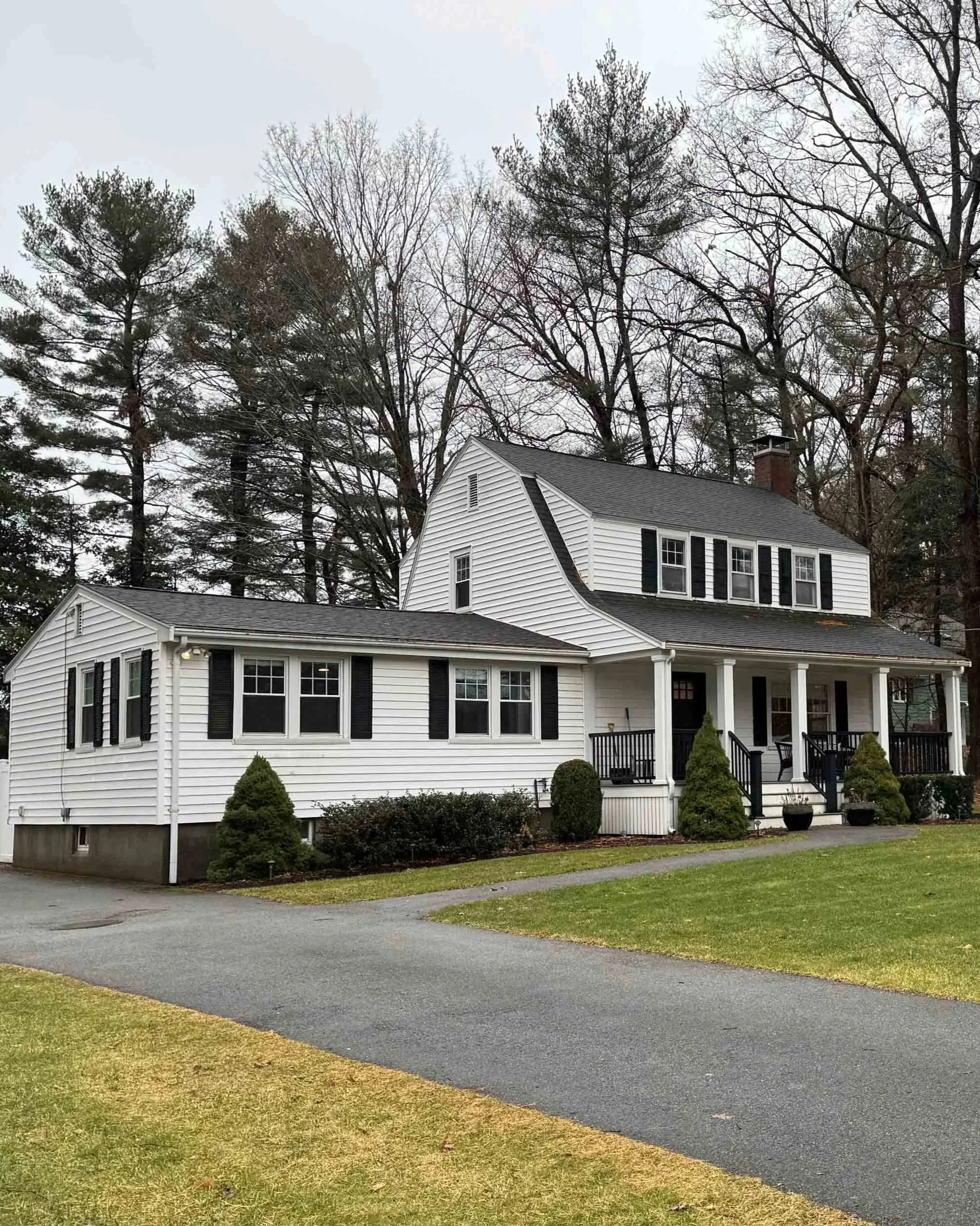 Front exterior of an existing Dutch colonial-style home in Greater Boston, prior to a comprehensive architectural renovation and two-story addition.