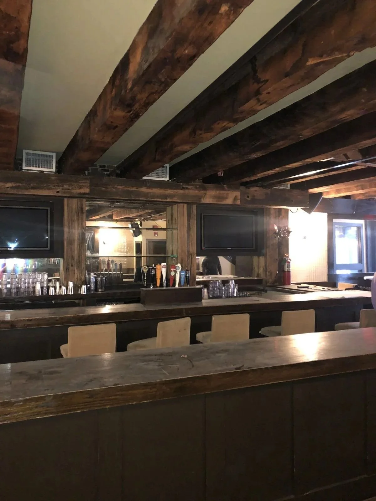 Original heavy timber beams over dusty old bar in downtown Boston prior to renovation.