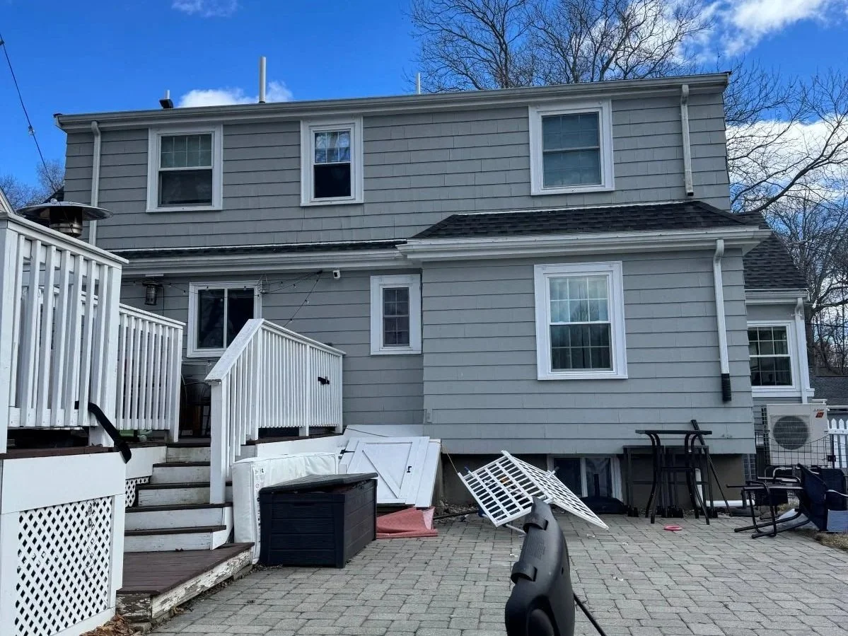 Existing rear of cape style home in Melrose with deck and patio.