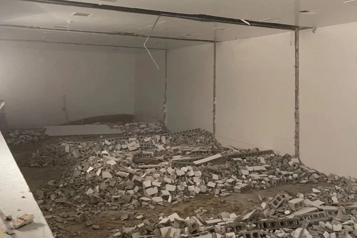  Large open space with piles of demolished cinder block during construction of new indoor pickleball courts