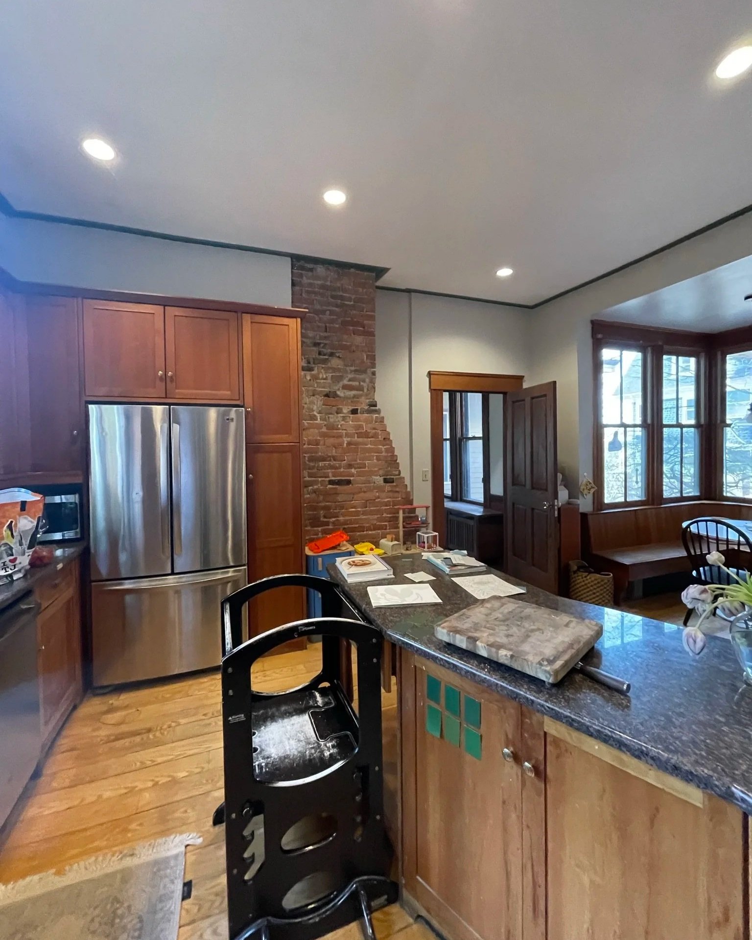 Existing kitchen with stained wood cabinetry and large chimney