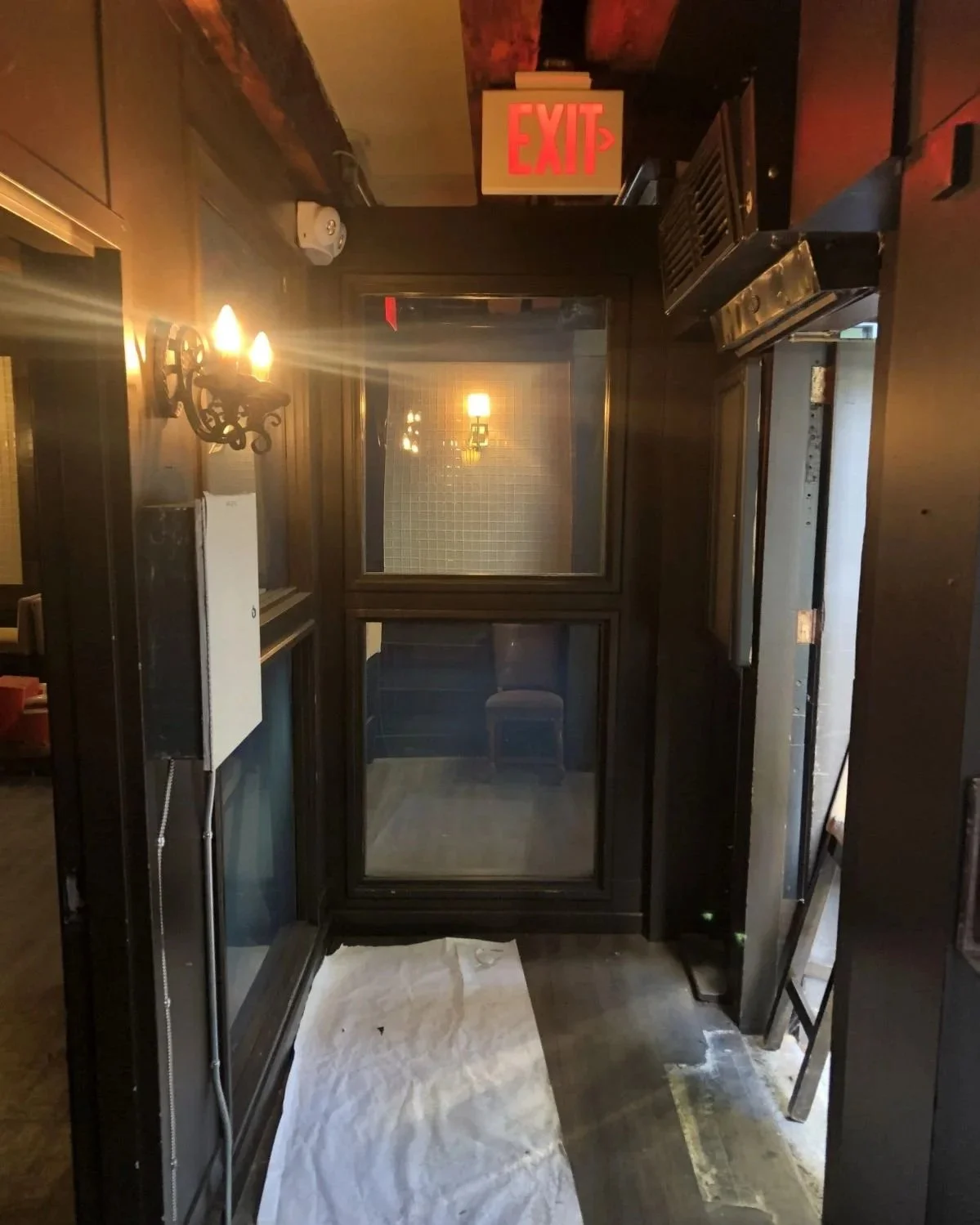 Original entry vestibule to old downtown Boston restaurant with dim lighting and exposed beams. 