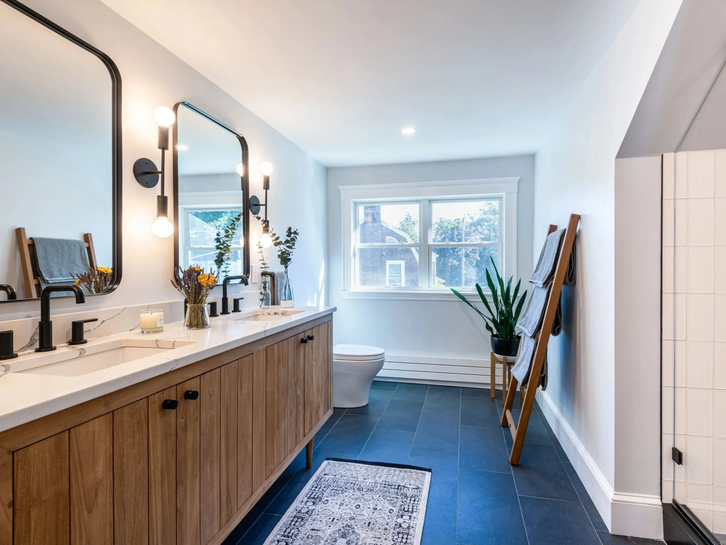 Full bathroom from bedroom conversion with modified double hung windows, teak vanity, charcoal blue tile floors and custom walk-in shower.