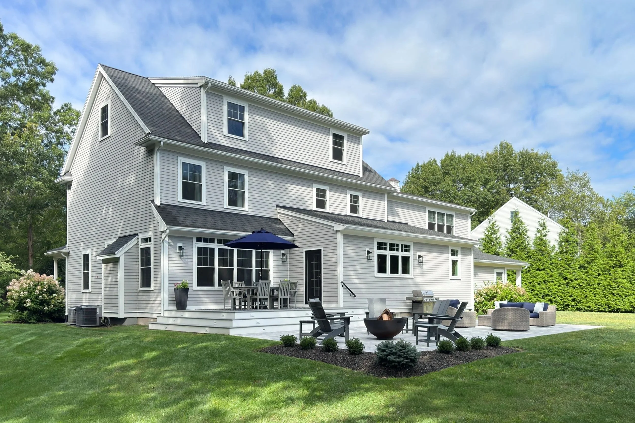 Rear facade and outdoor entertainment area of new additions on a North Shore home.