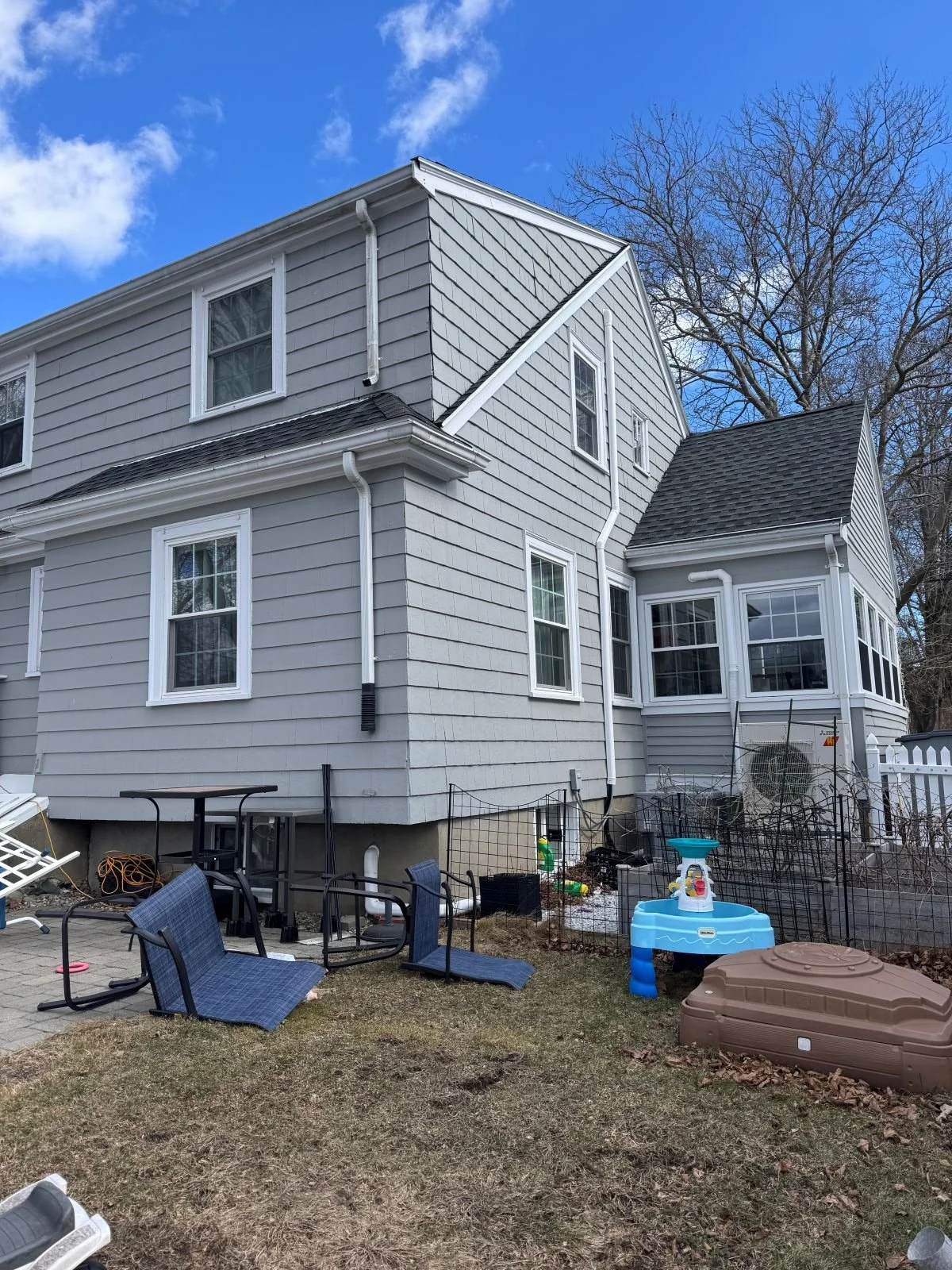 Side view of existing conditions of a colonial home in Melrose, MA prior to vaulted kitchen addition and basement stair walkout.