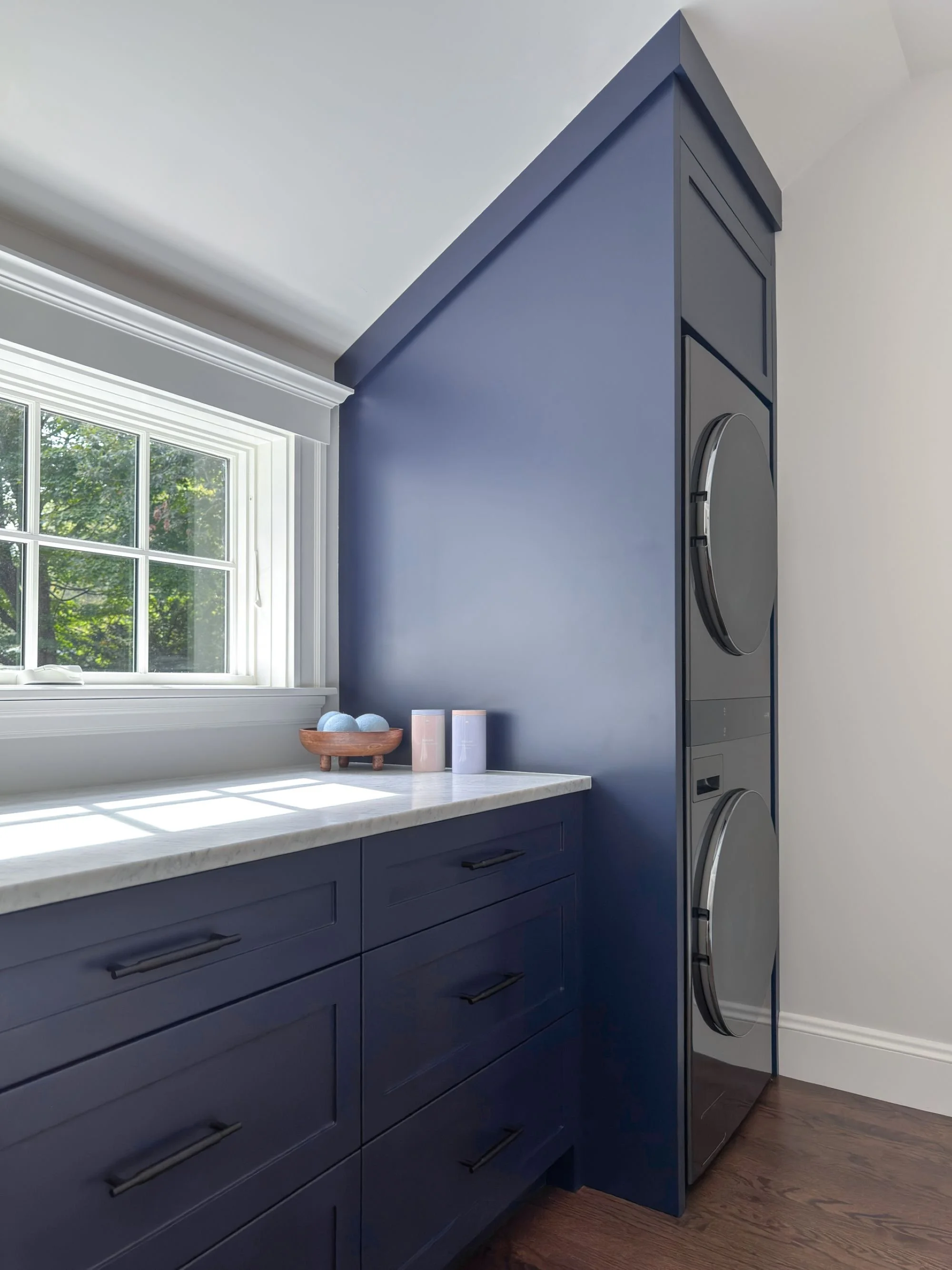 laundry station with floor to ceiling built-in cabinet for LG wash tower machines with adjacent double drawer base and marble countertop for folding and linen storage
