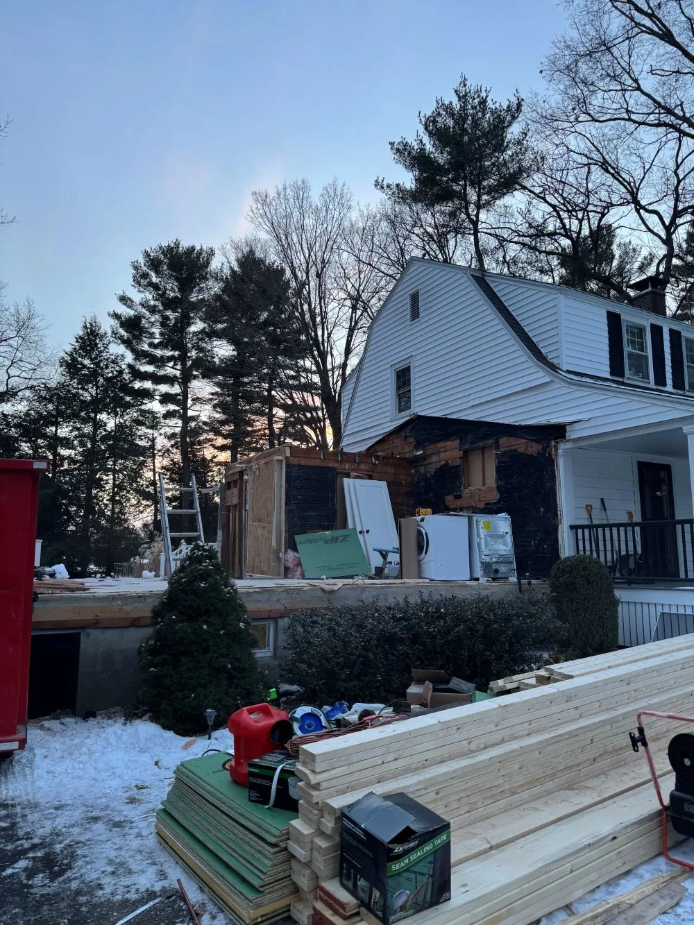 Exterior demolition phase of a Dutch Colonial second story addition in Greater Boston showing removal of existing one story addition structure designed by Tact and Grit Design Co.