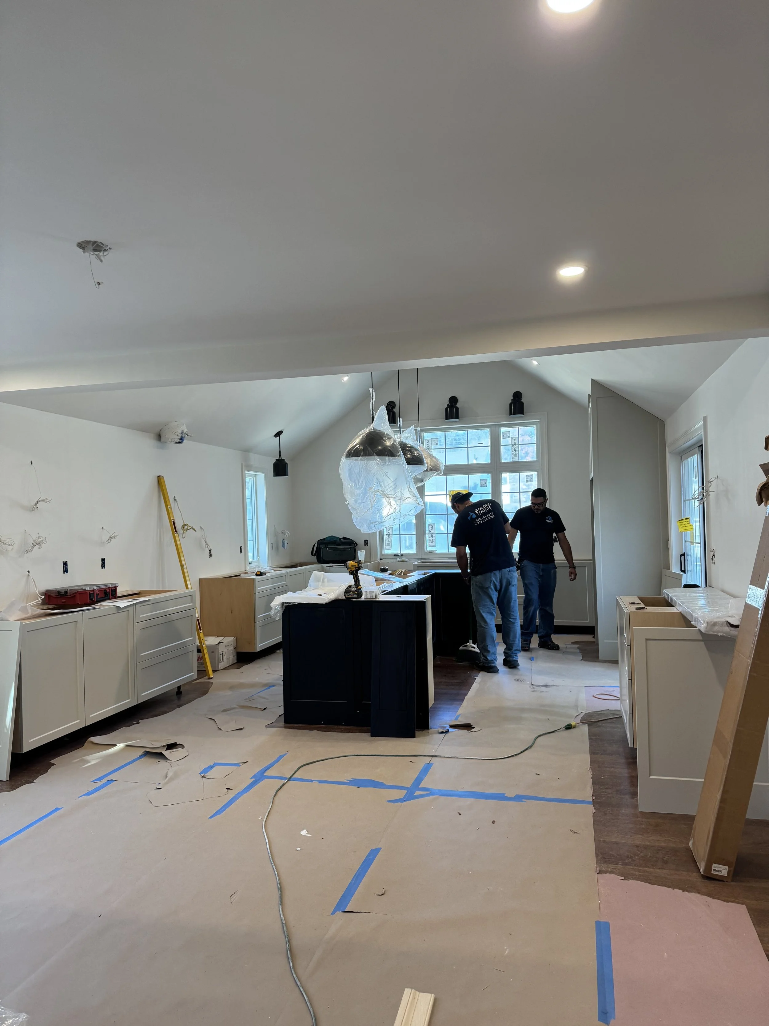 Millwork Integration: Installation of the custom cabinetry and the 10-foot black stained oak island within the vaulted kitchen addition.